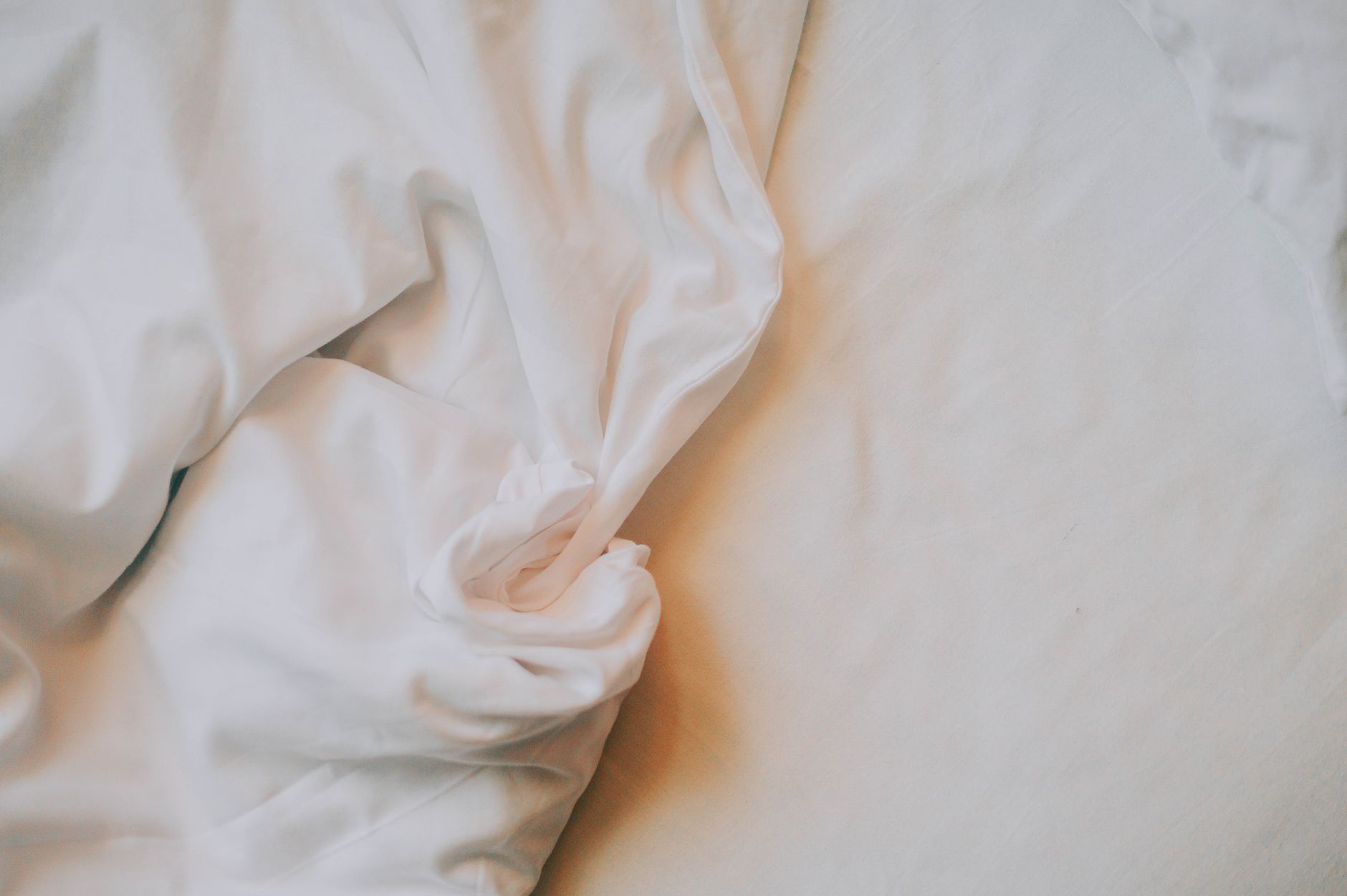 Best mattress vacuum: rumpled white bed sheets