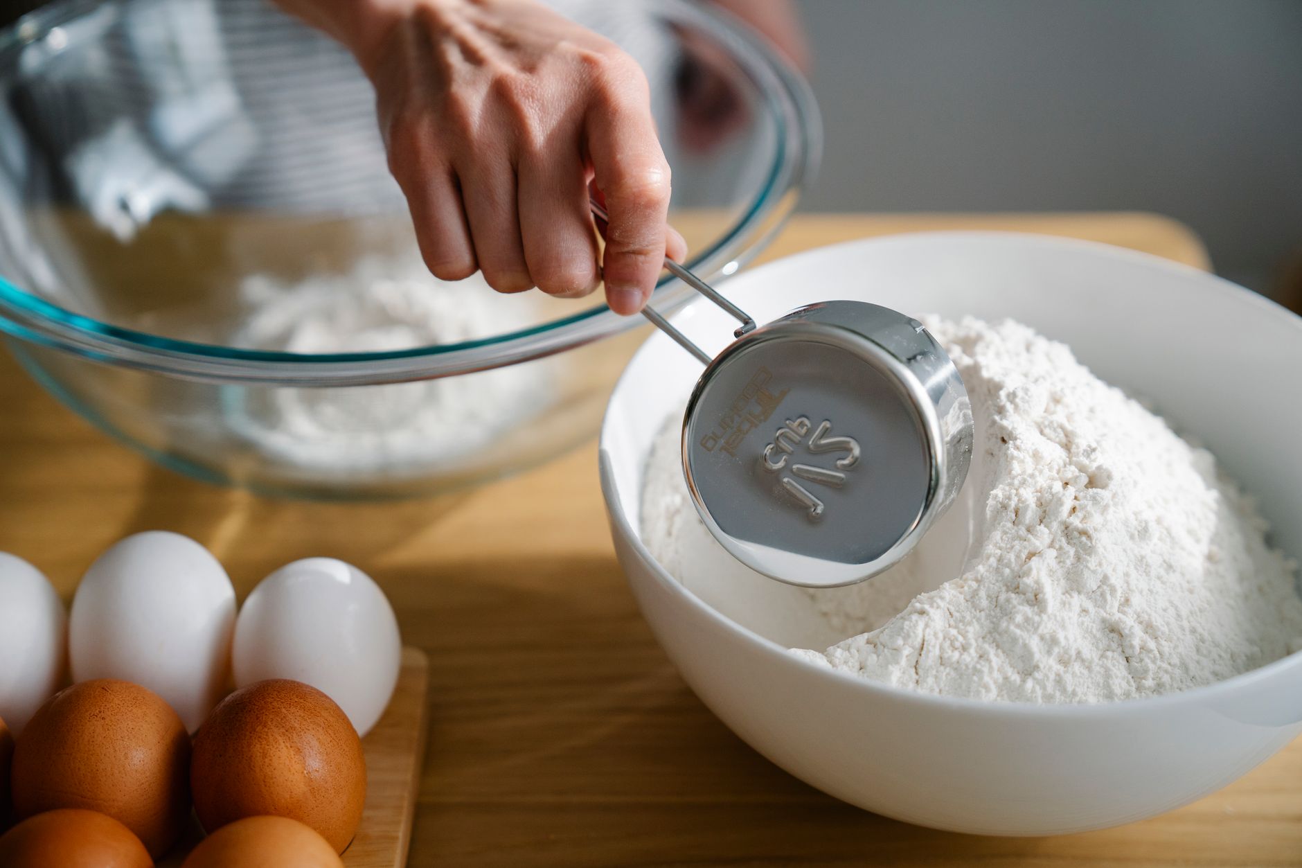 Scooping flour with a measuring cup