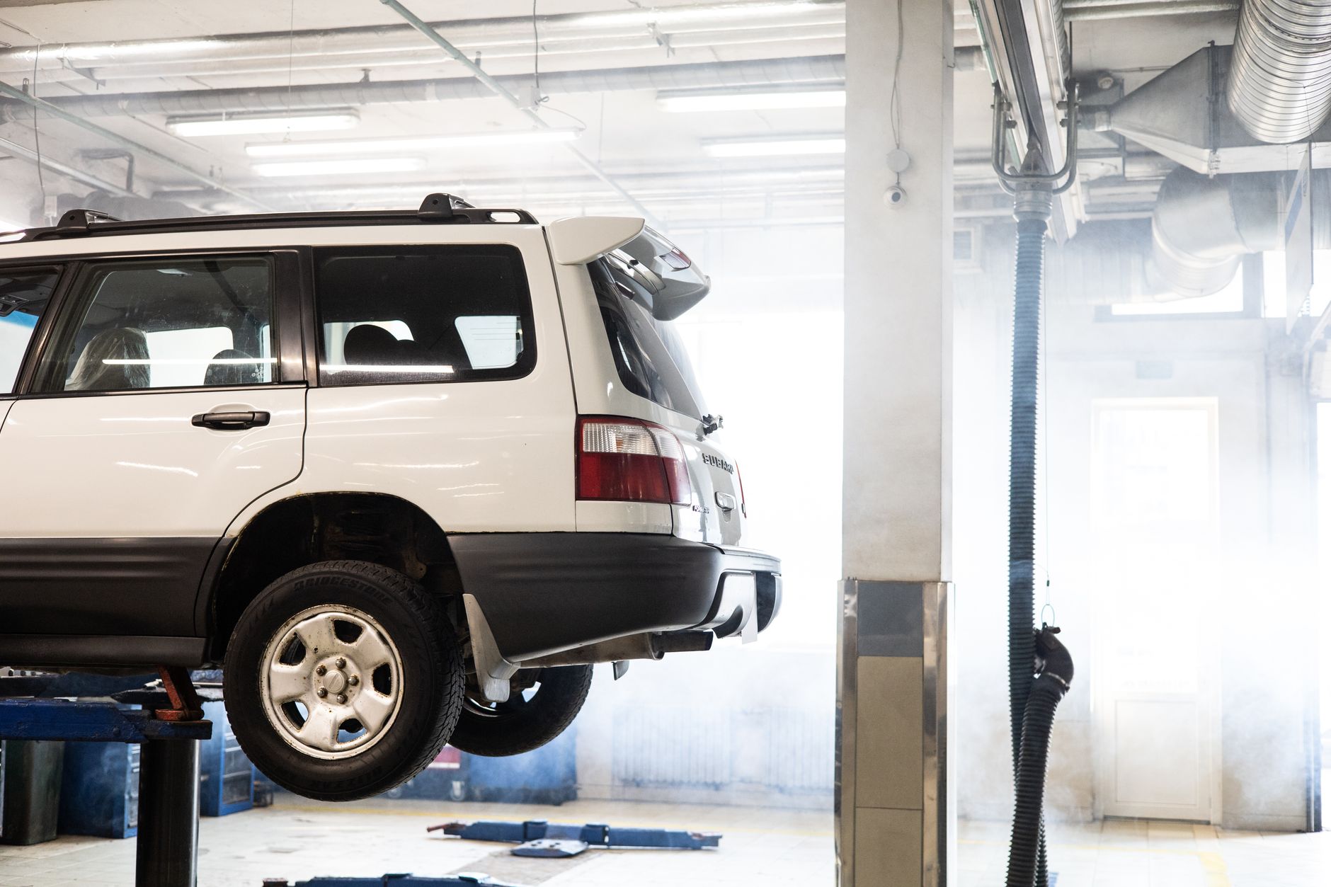 Best mechanic creeper: an SUV raised on a lift in a garage