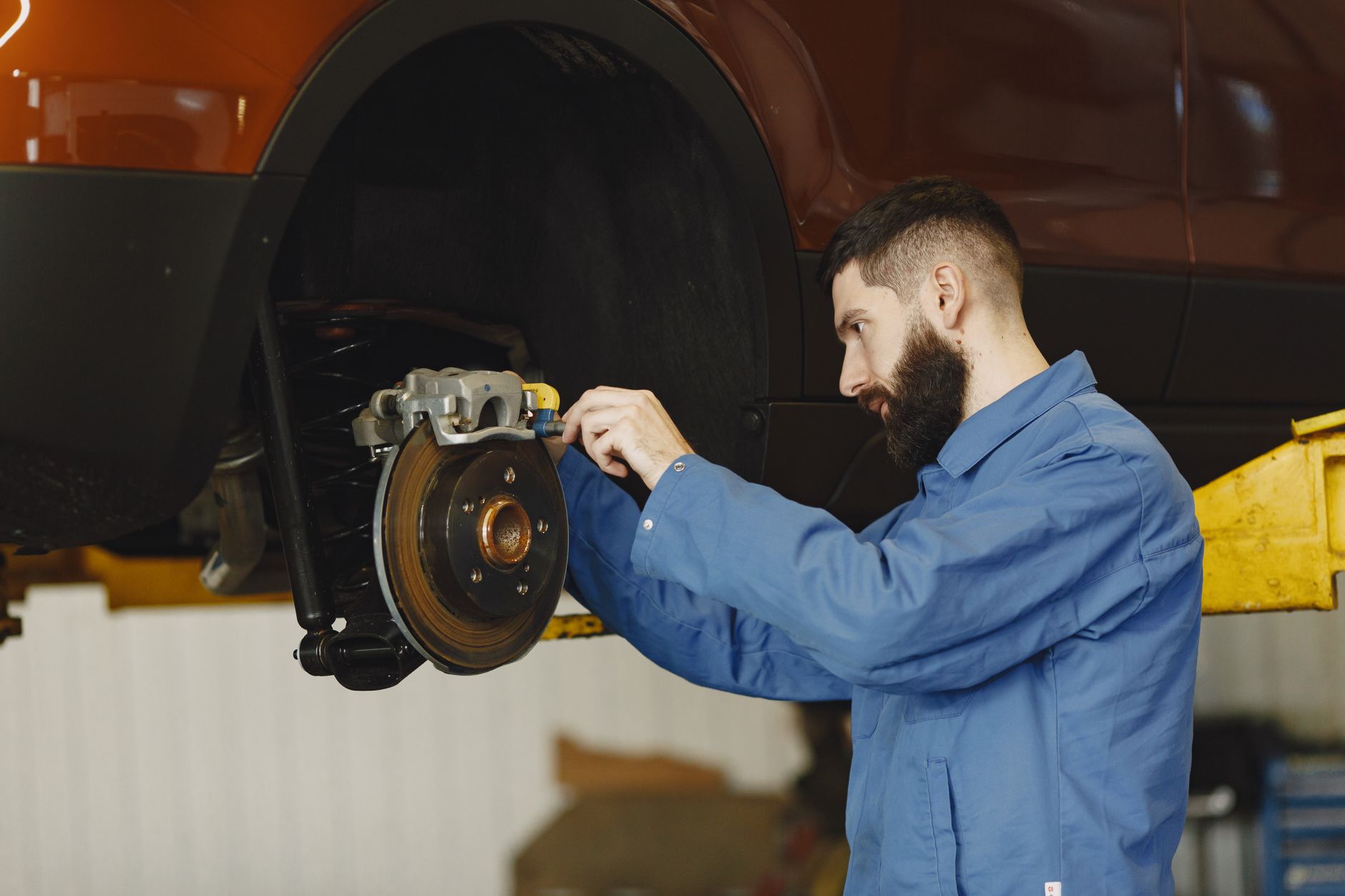 A mechanic checking a brake caliper