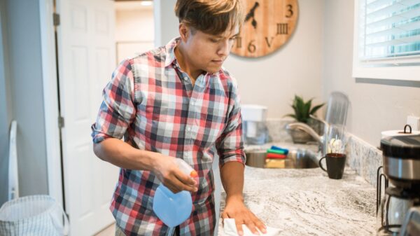 A man wiping a kitchen counter