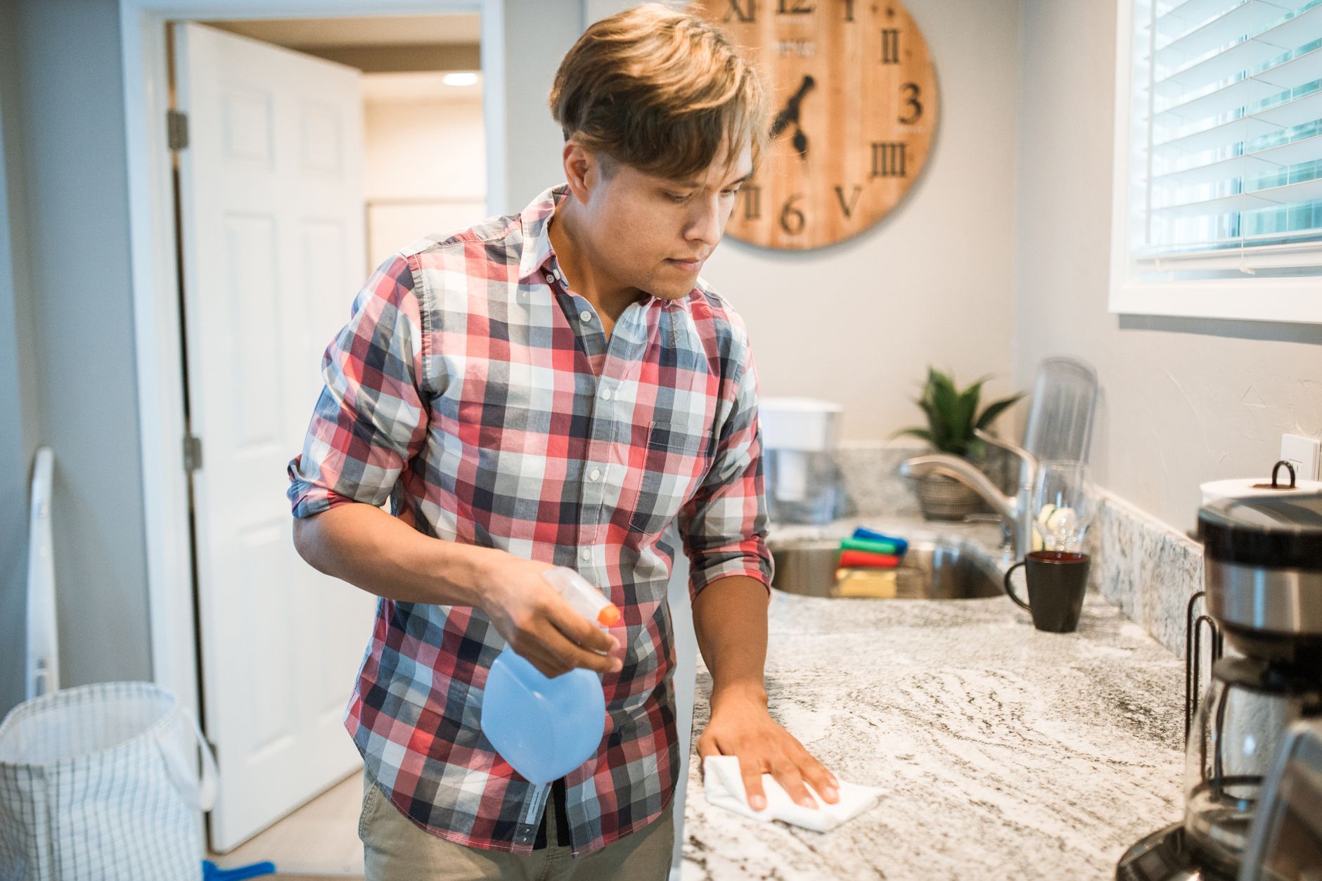 A man wiping a kitchen counter