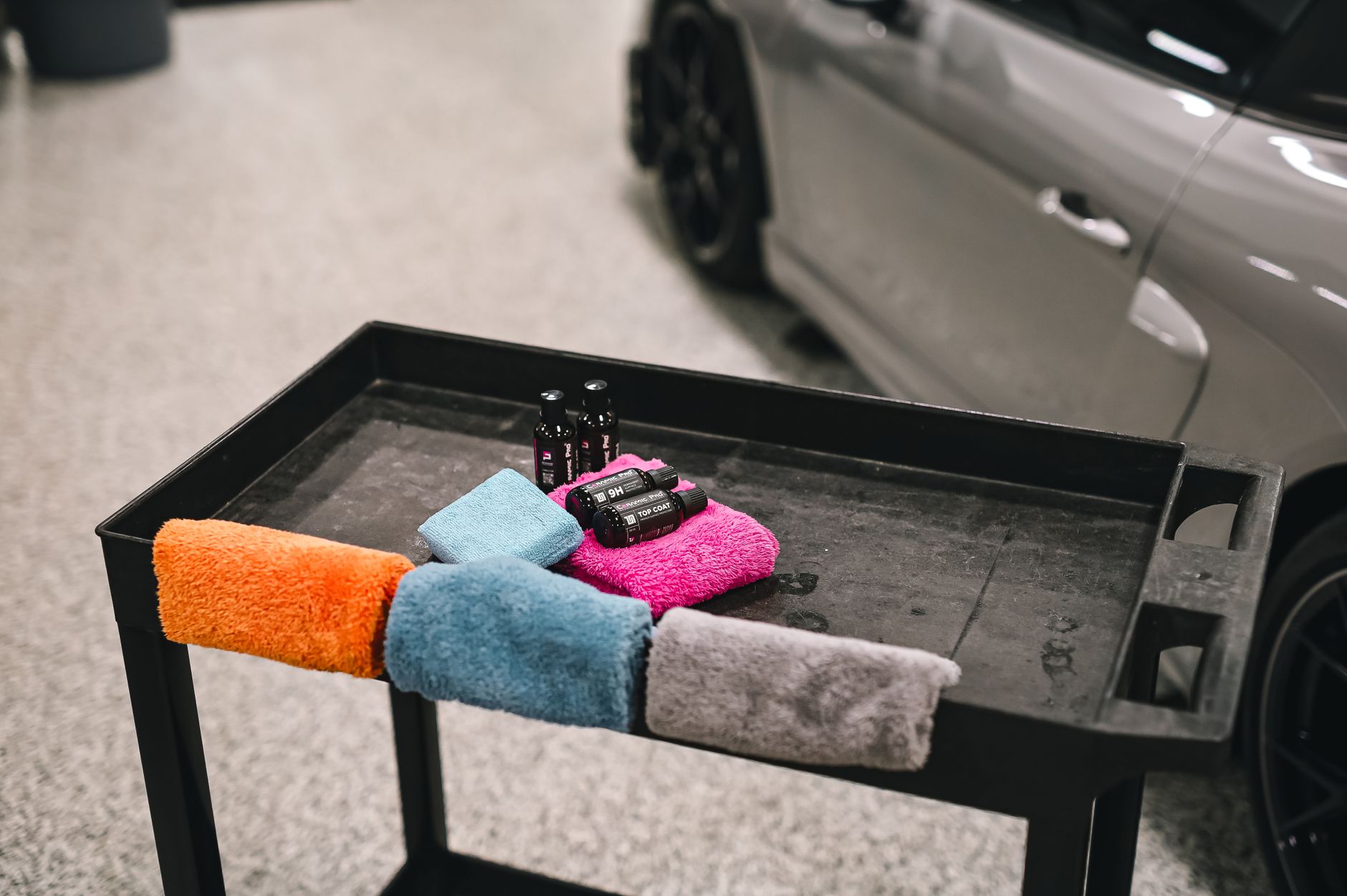 Colorful towels on a cart next to a car