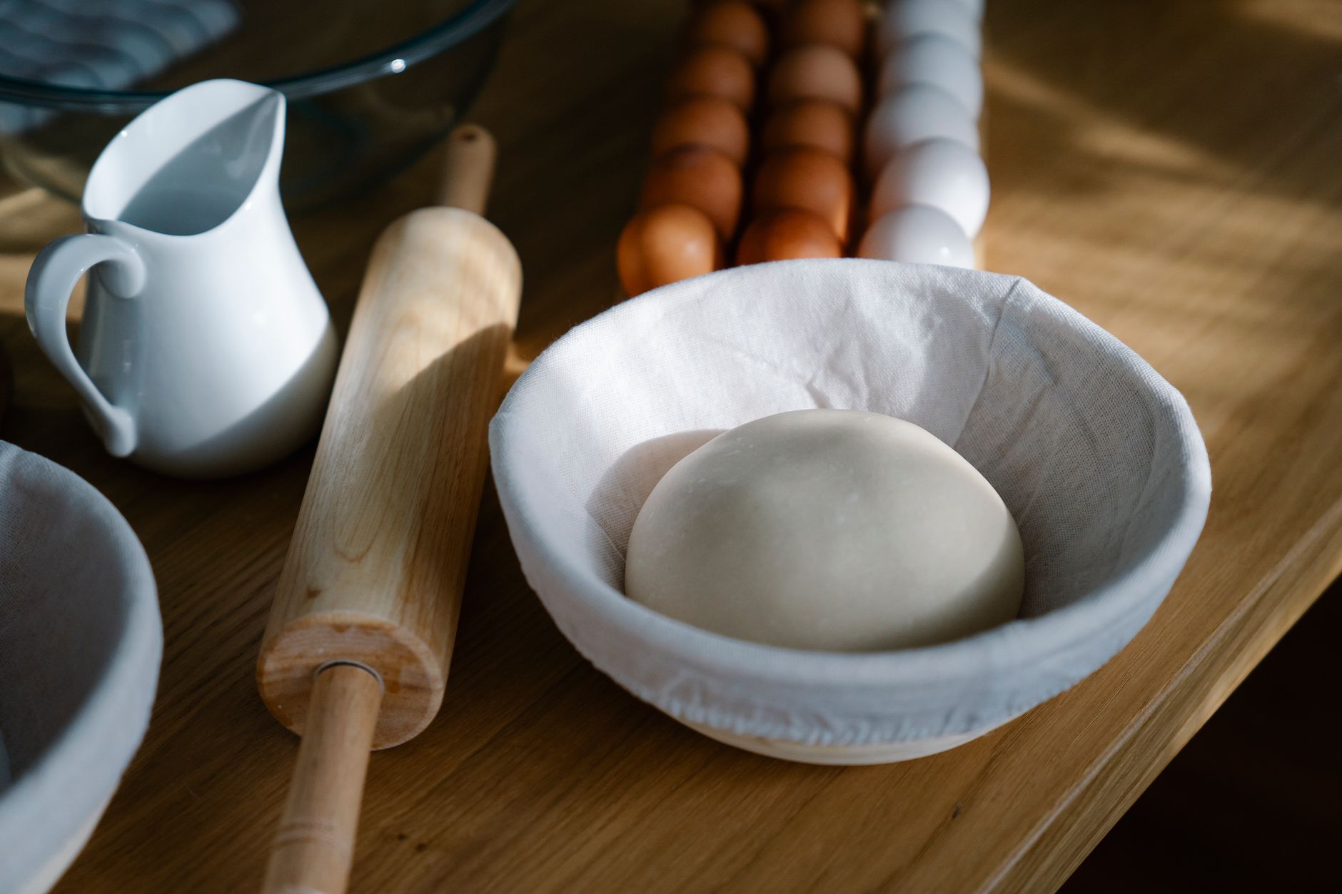 Bread dough resting in a cloth-lined bowl