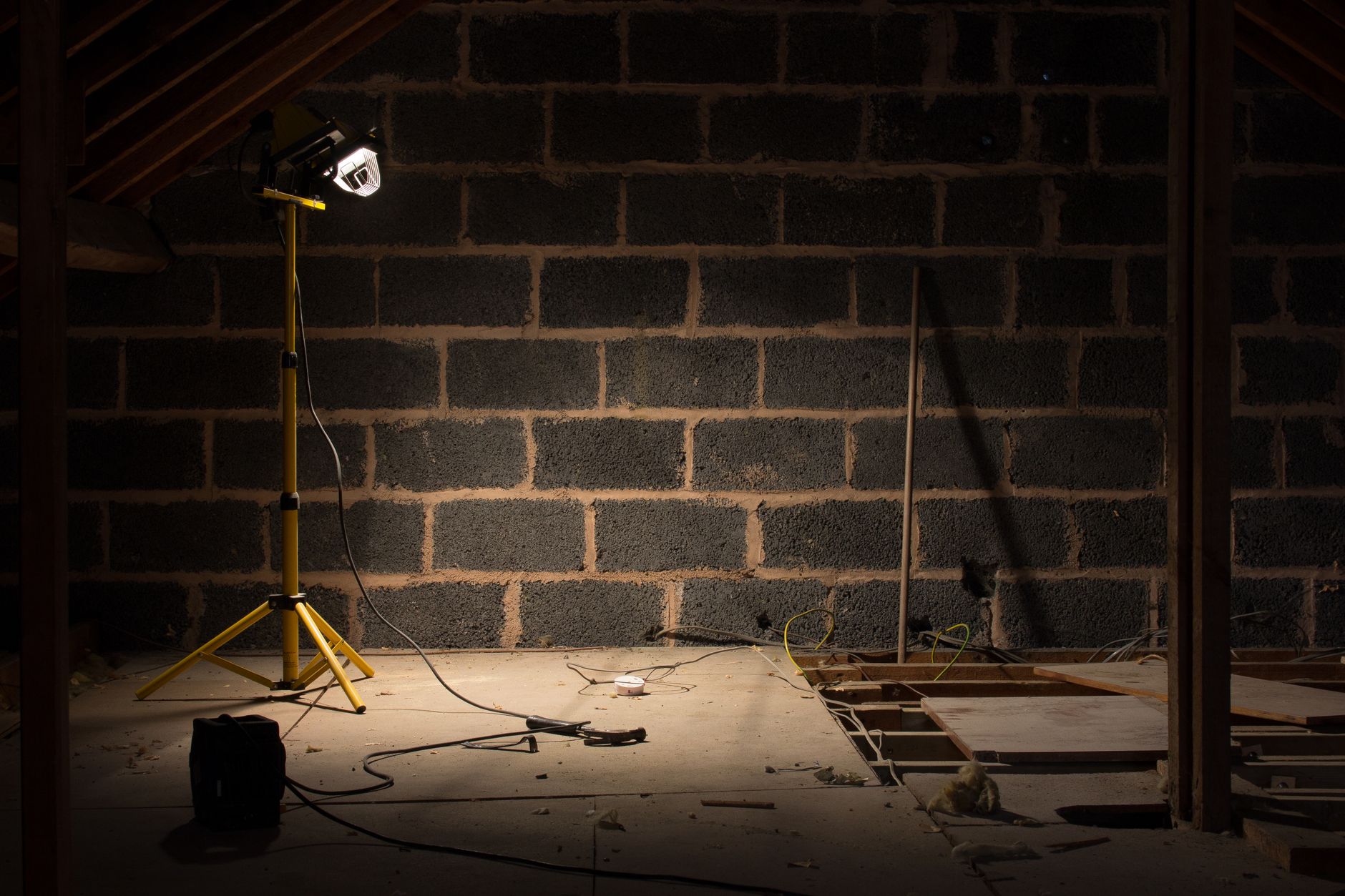 A bare block wall lit by a work light during a renovation