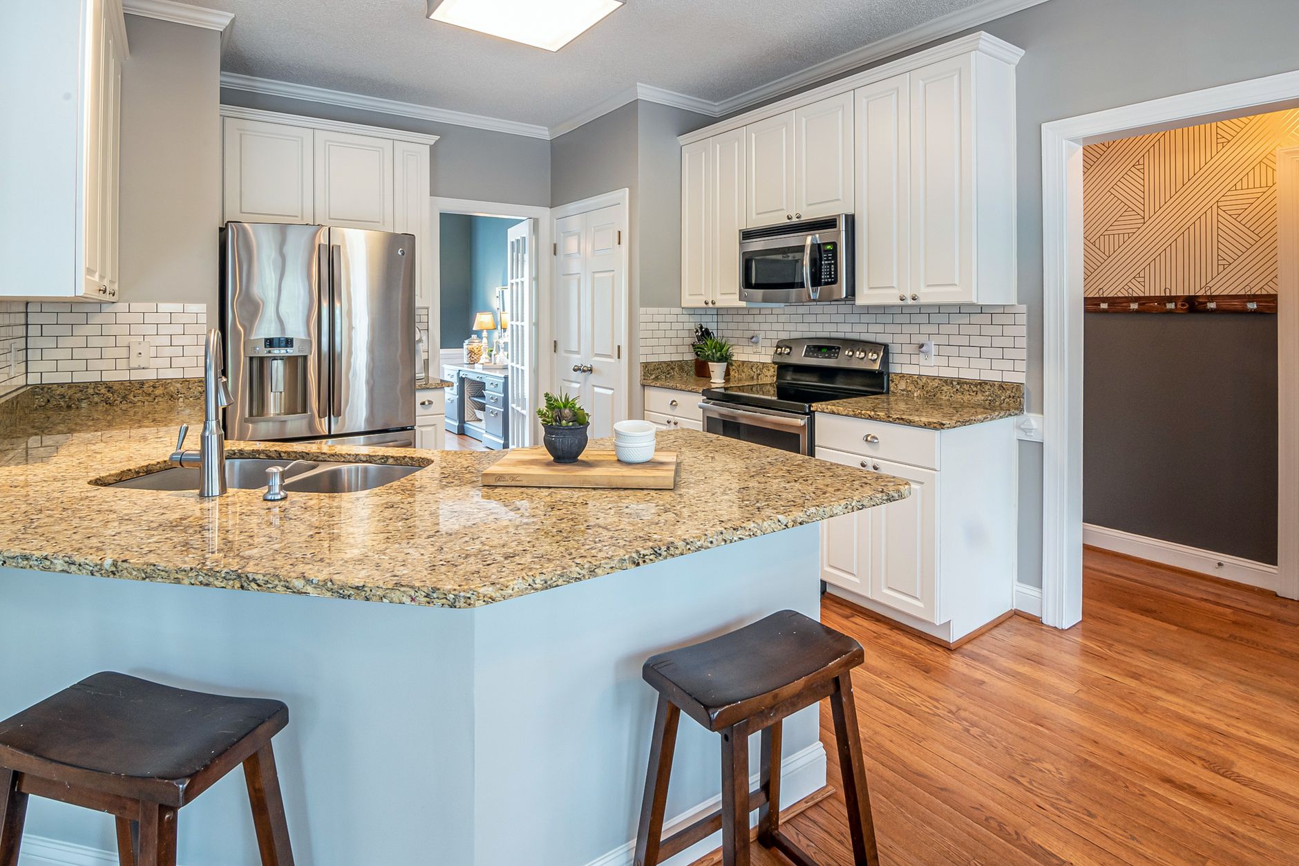 A bright kitchen with a sink and island