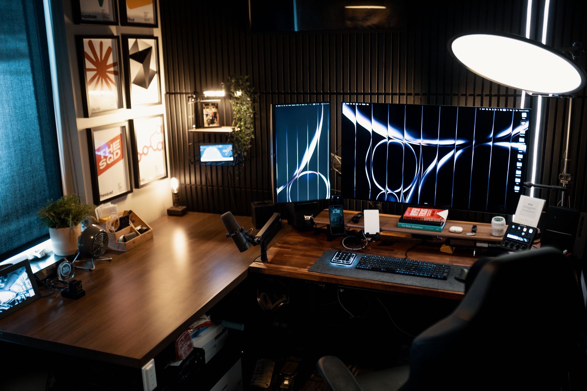 A dual-monitor setup on a dark wood desk