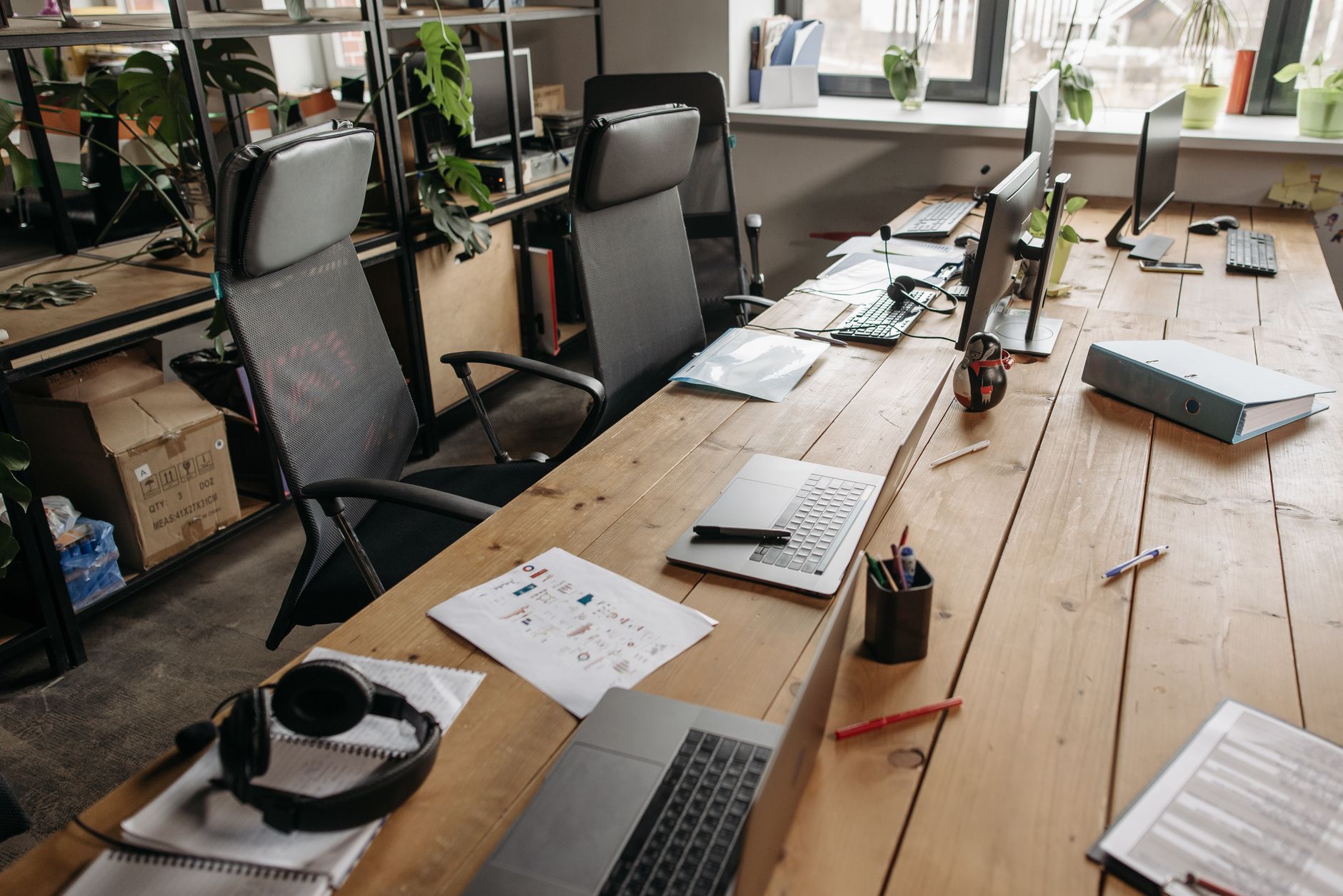A shared office desk with monitors and chairs