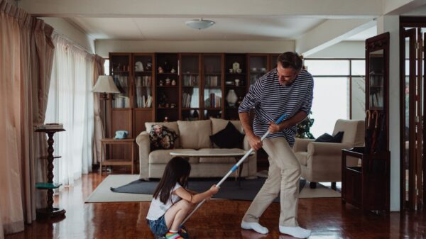 A parent and child mopping a wood floor