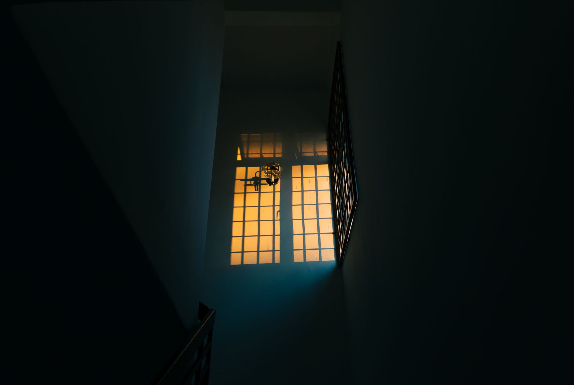 A dark stairwell with a lit window