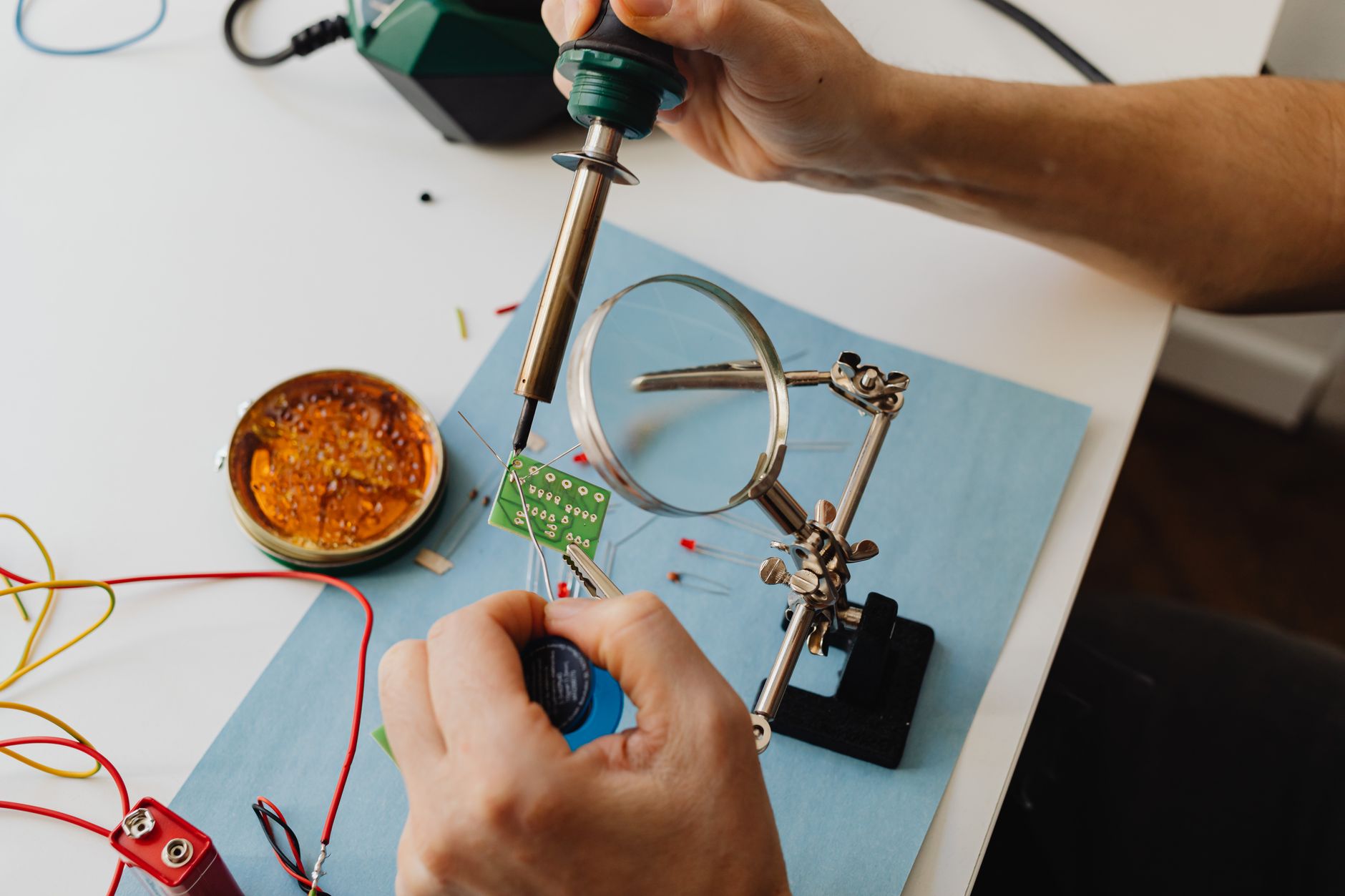 Soldering a small circuit board at a workbench