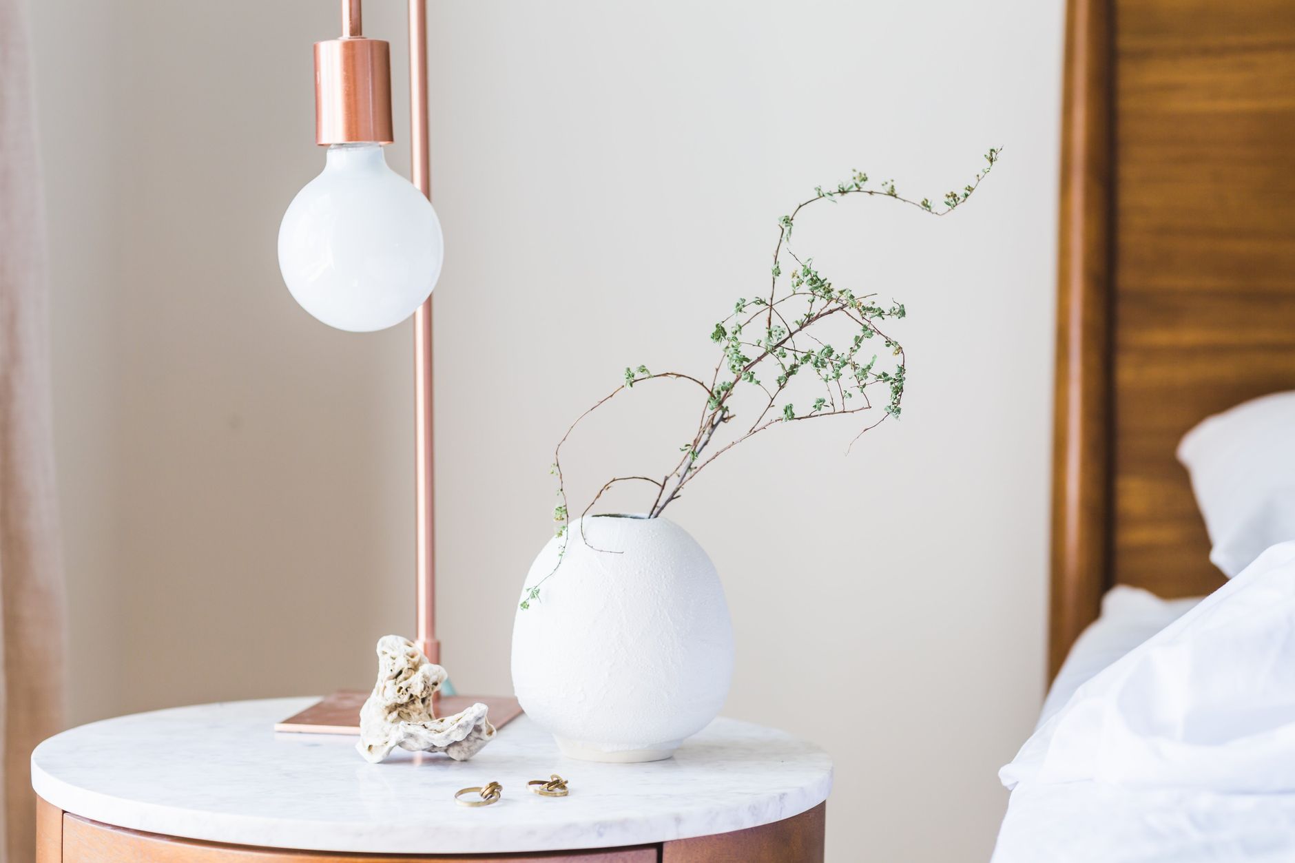 Best nightstand: a bedside table with a lamp next to a made bed