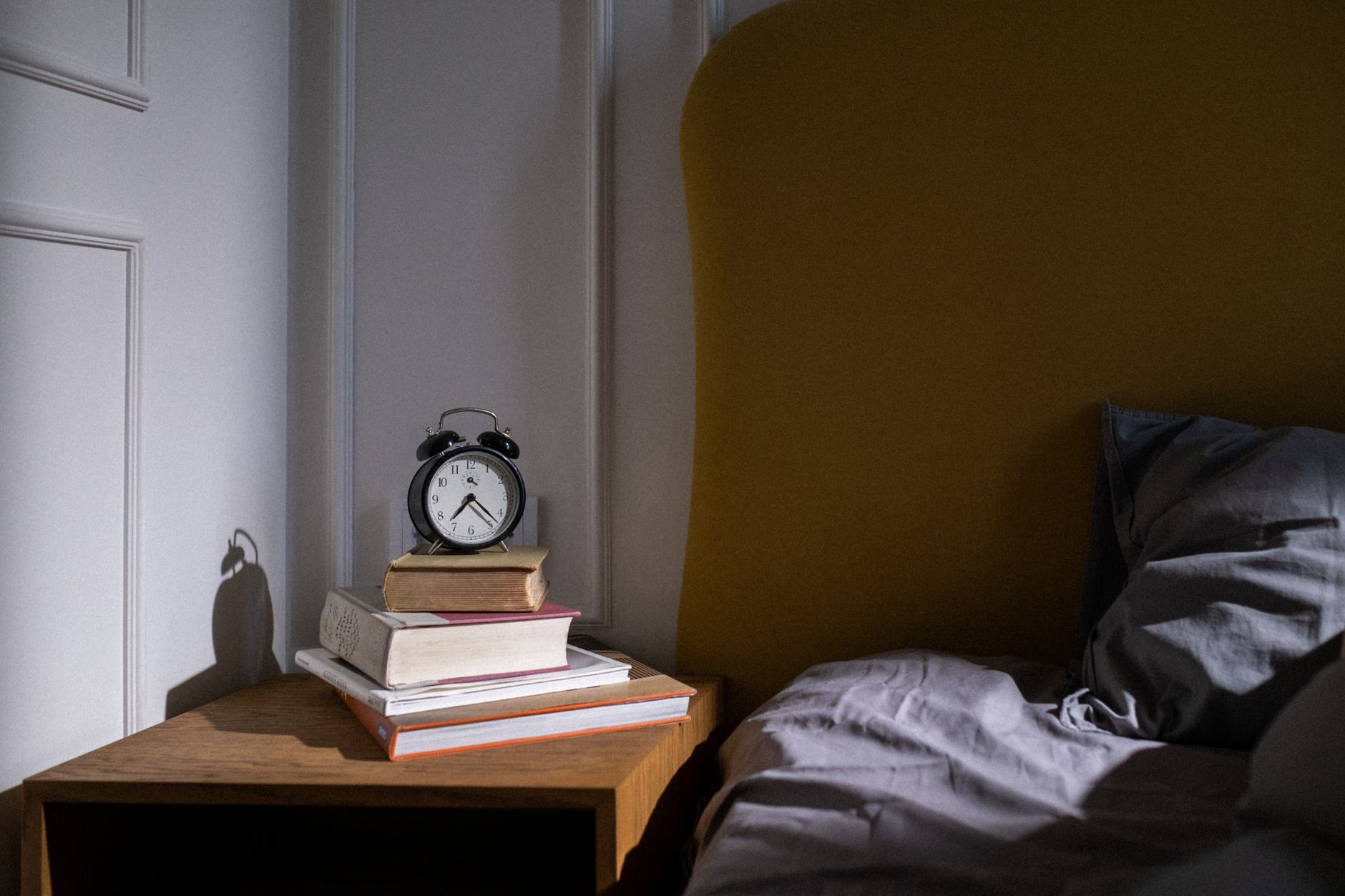 A stack of books on a bedside table
