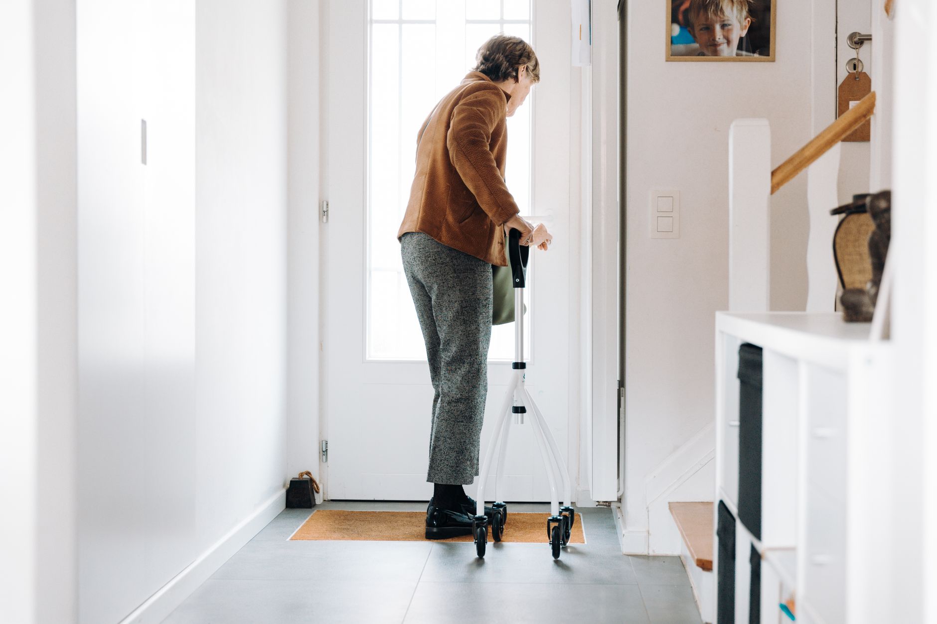 An older adult walking through a home hallway