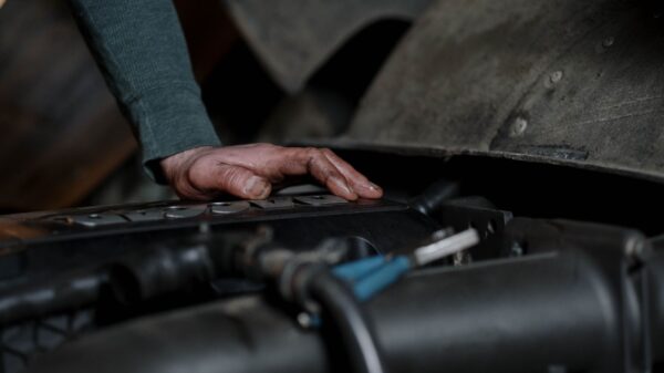 Best oil drain pan: a hand resting on a car engine