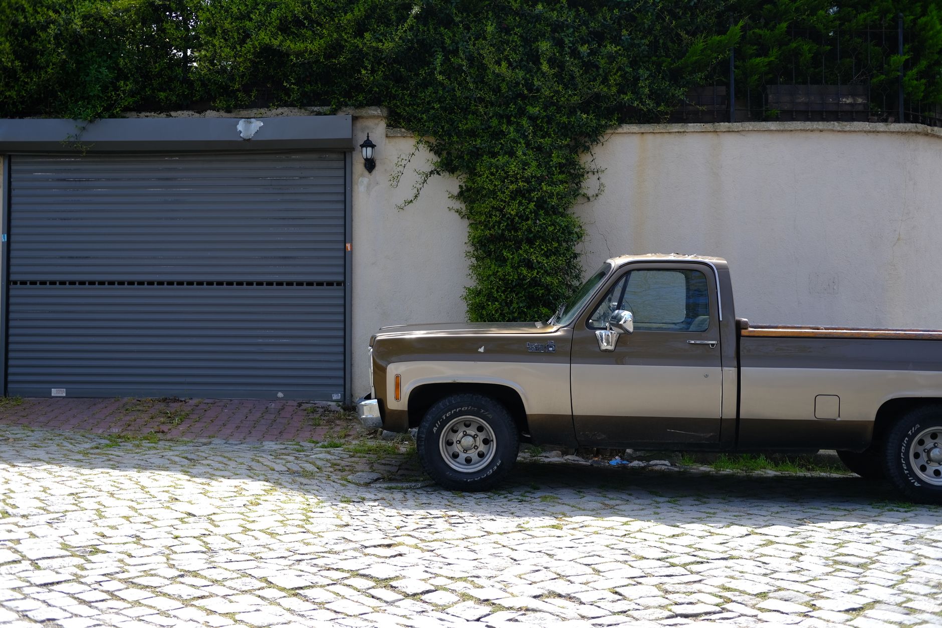 A pickup truck parked by a garage door