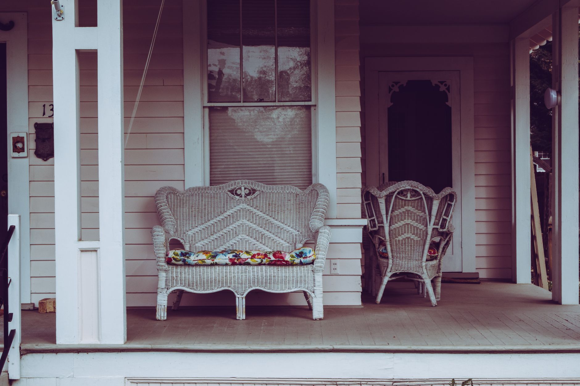 A wicker chair on a front porch