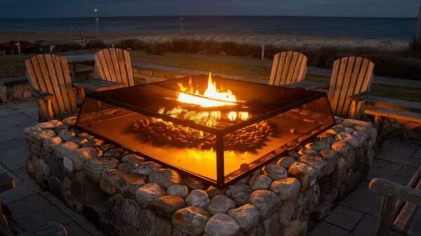 Best outdoor fireplace: a stone fire pit with chairs at dusk