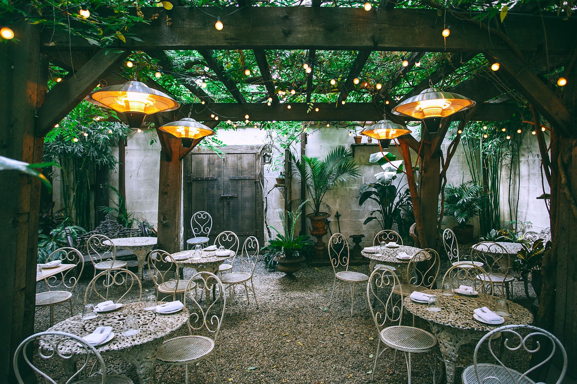 String lights and heaters over a courtyard dining area