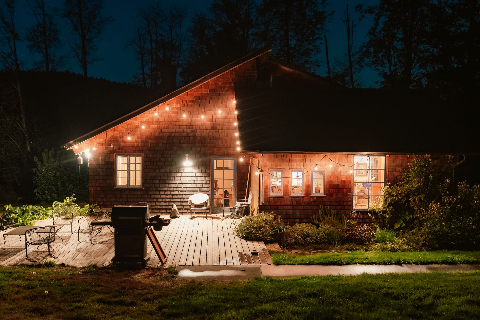 String lights along the eaves of a cabin at night