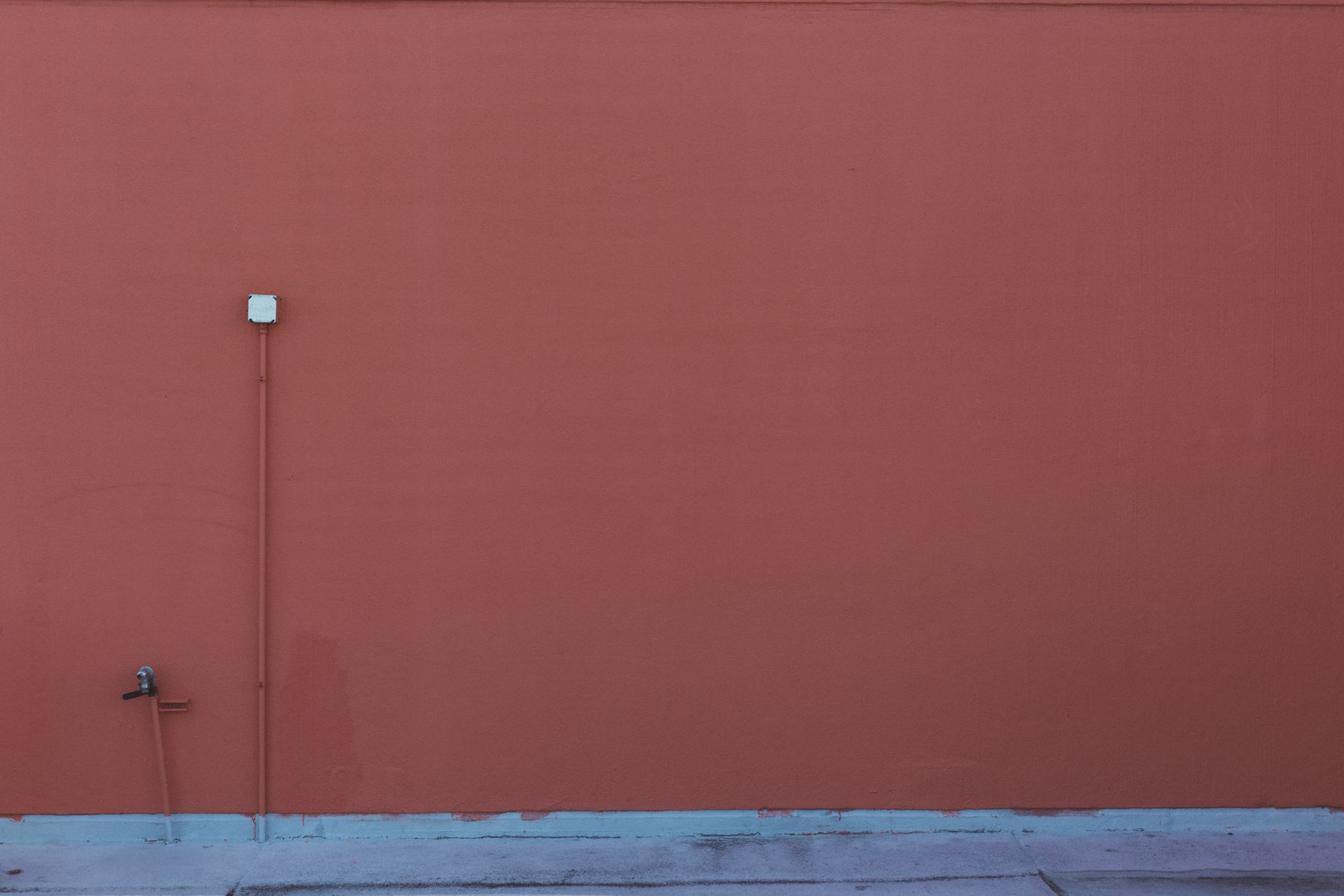 An outdoor outlet on a red exterior wall