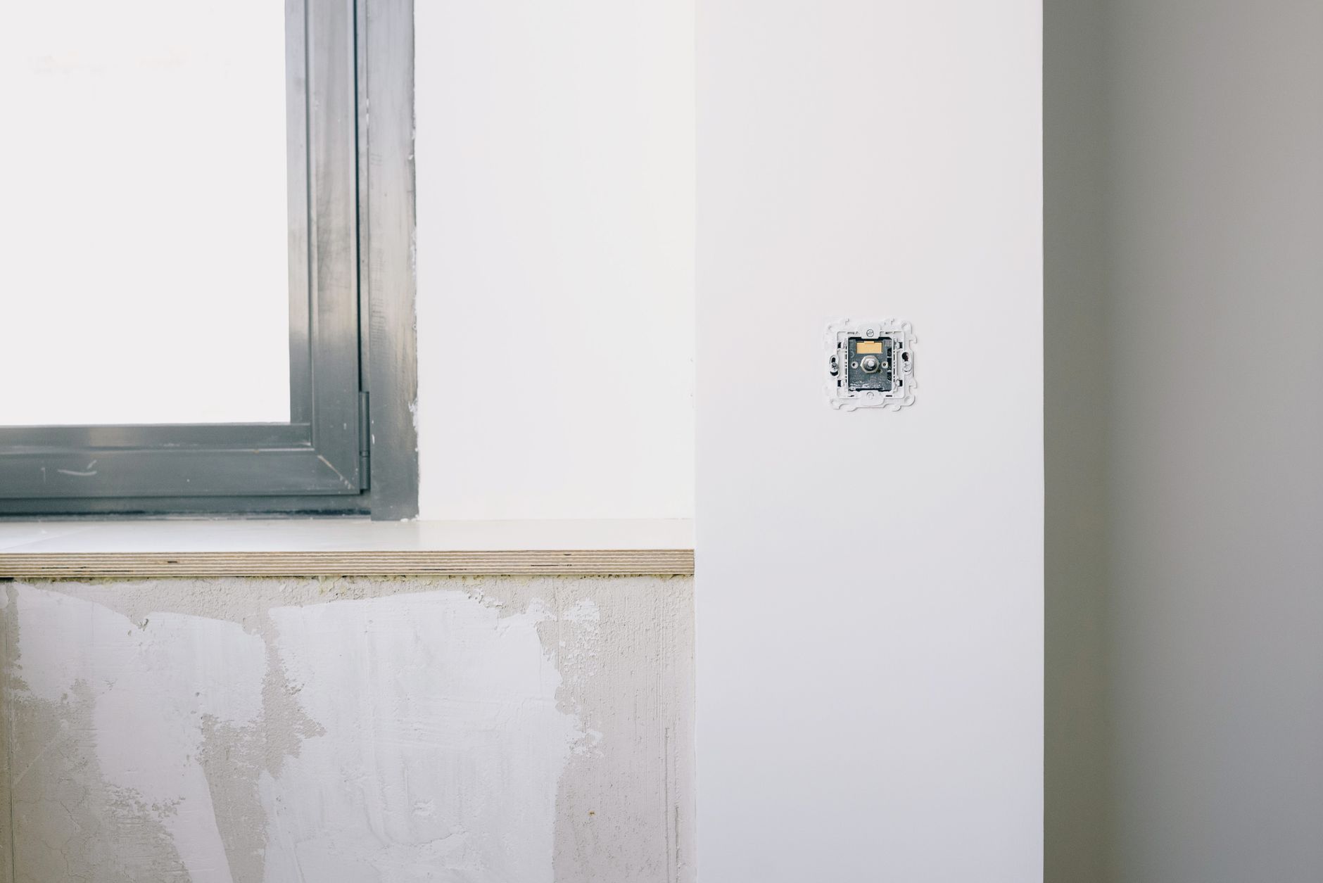 A wall outlet next to a window
