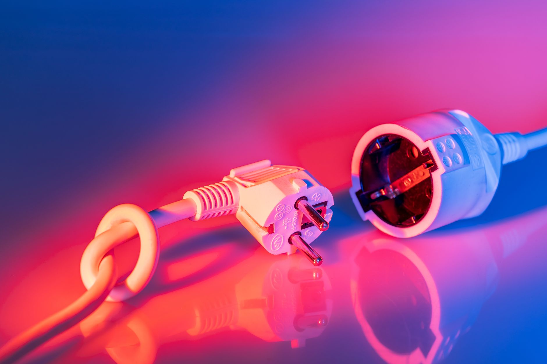 An electrical plug and socket under red and blue light
