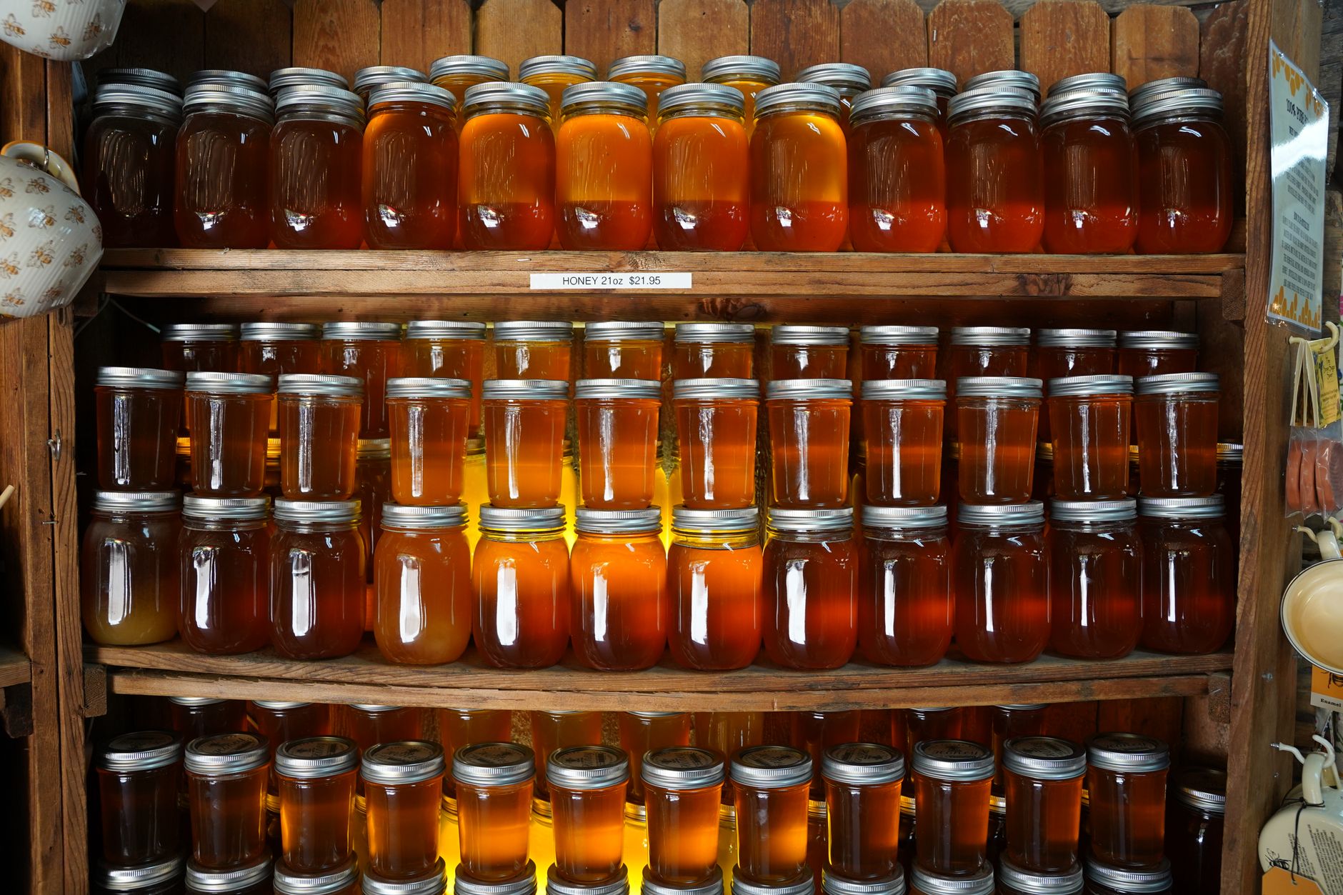 Rows of honey jars on wooden shelves