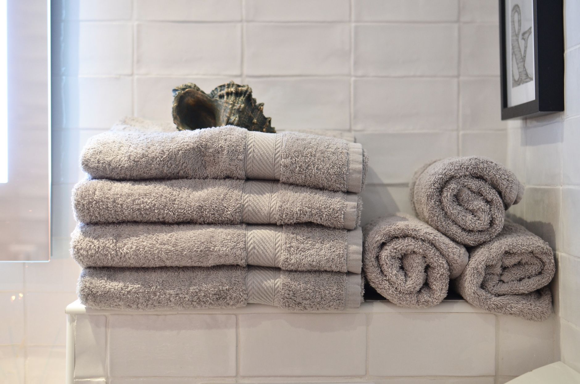 Folded and rolled towels on a bathroom shelf
