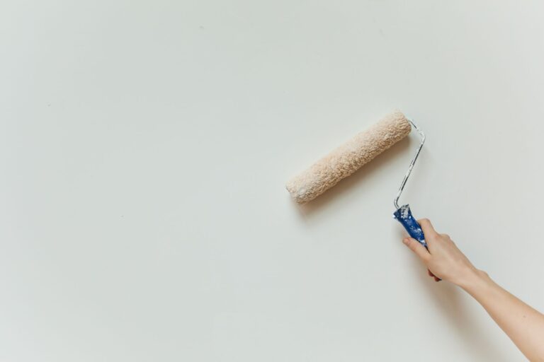 Best paint roller: a roller spreading fresh paint on an interior wall