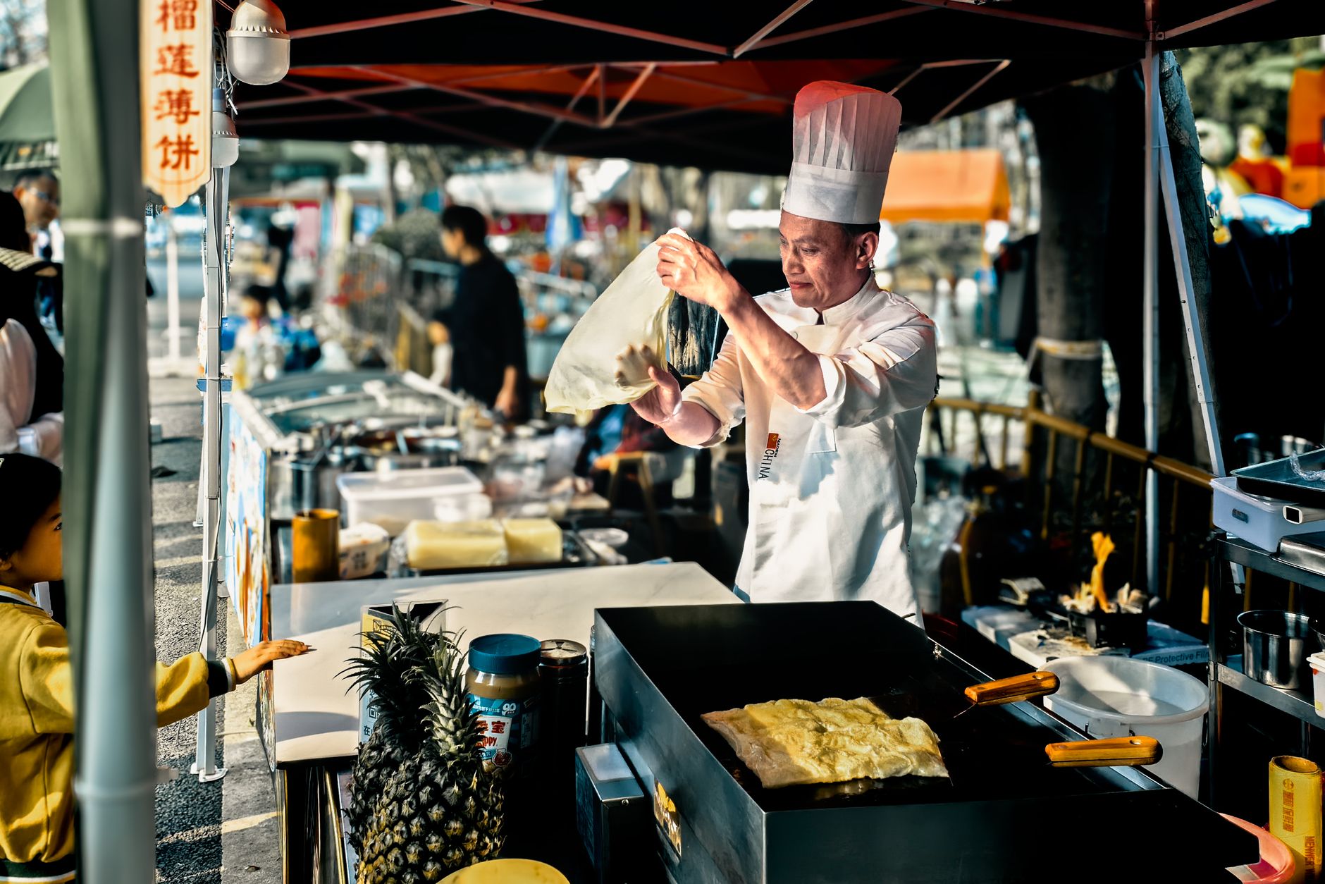 A street cook making flatbread on a griddle