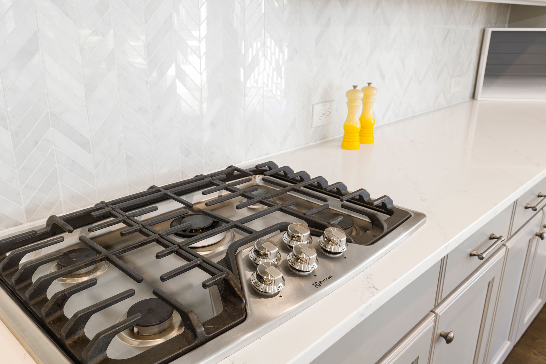 A gas cooktop on a white counter