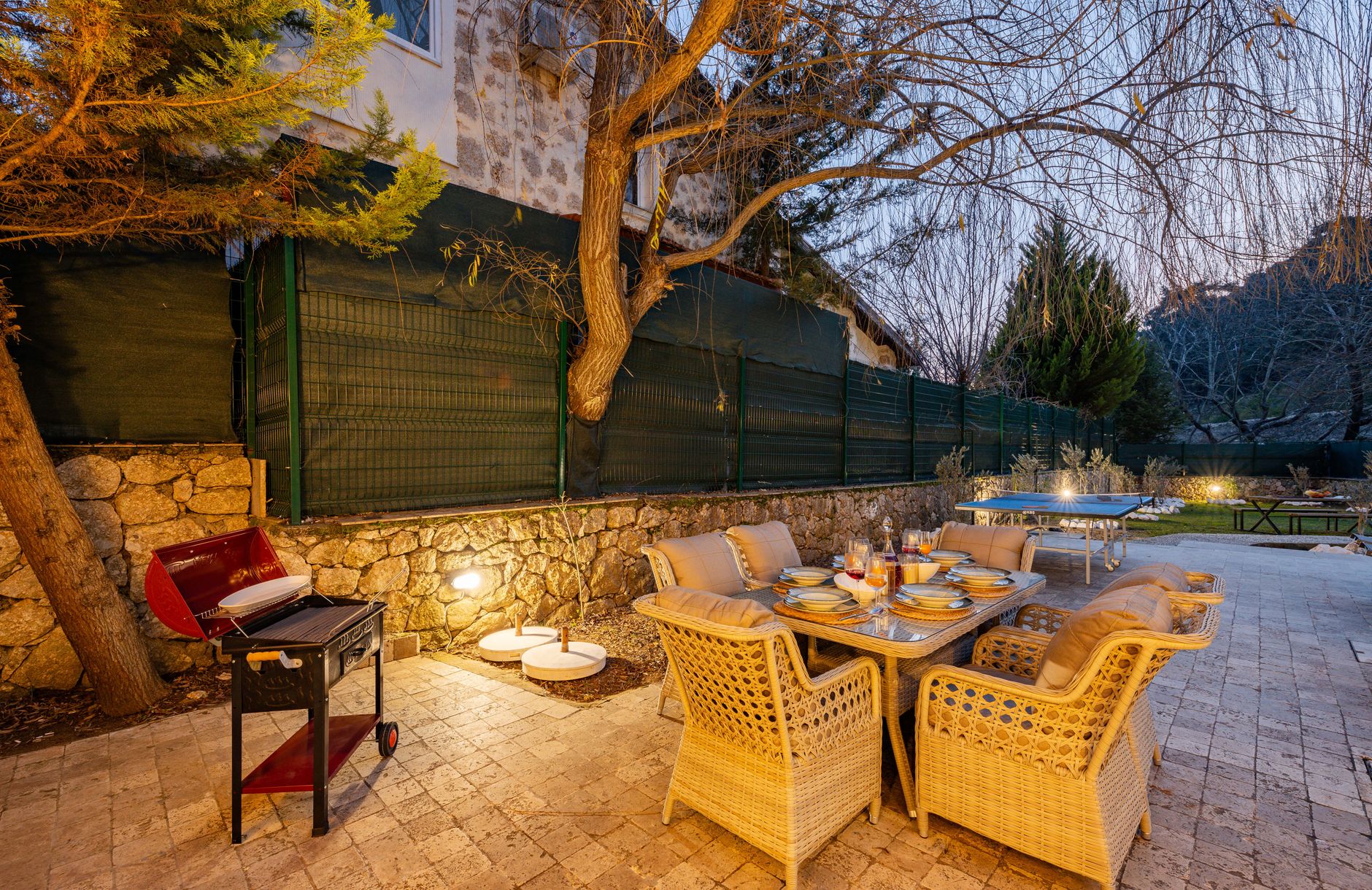 Wicker patio furniture lit at dusk
