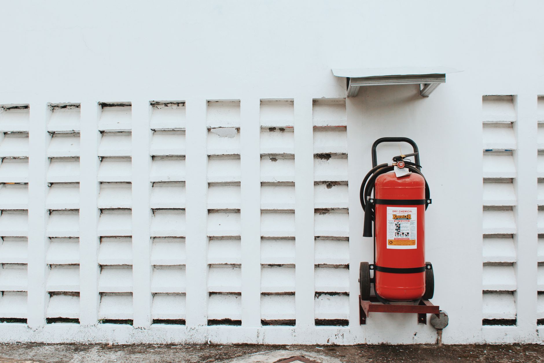 A fire extinguisher mounted on a white wall