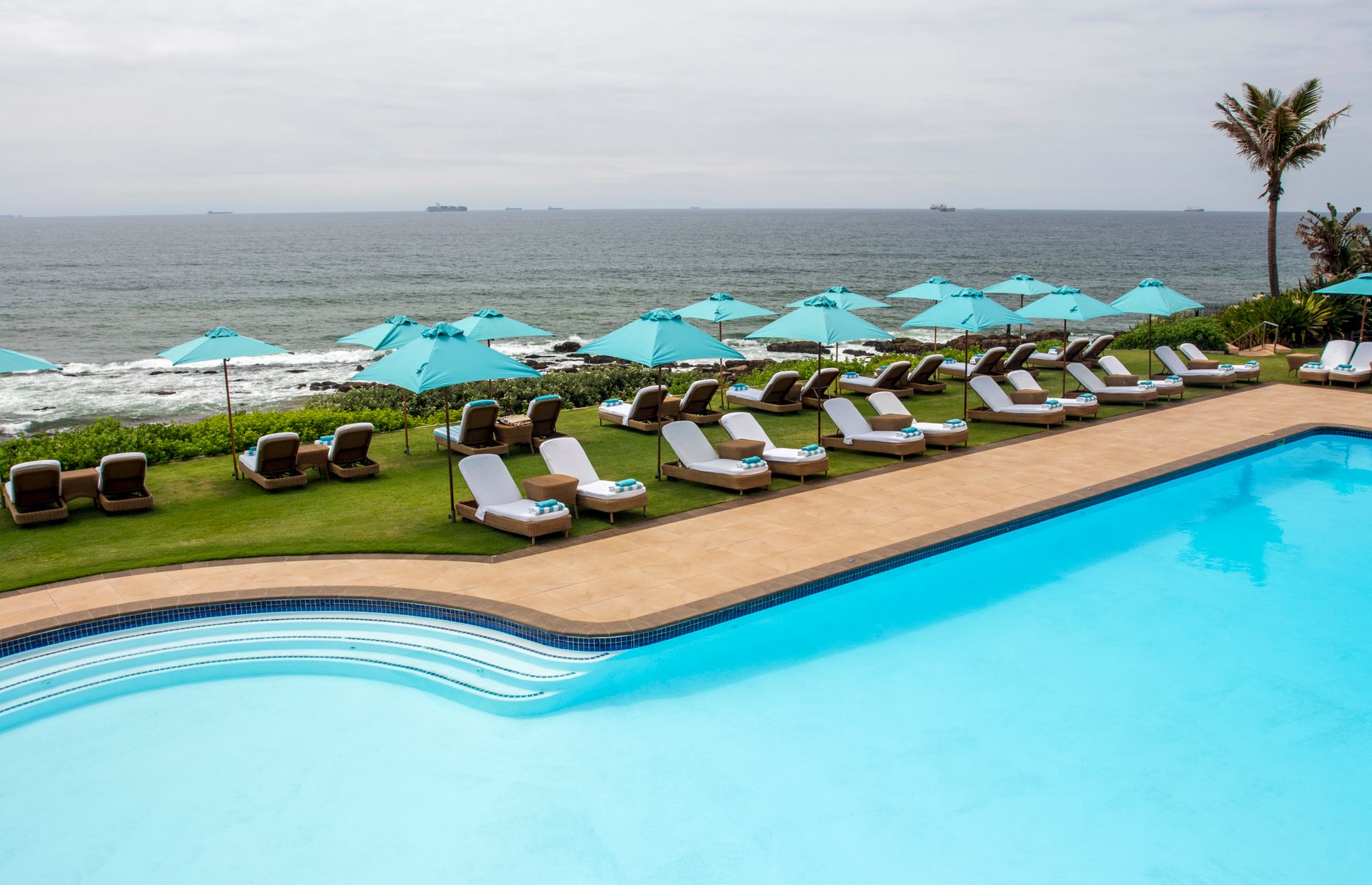 Lounge chairs and an umbrella beside a pool