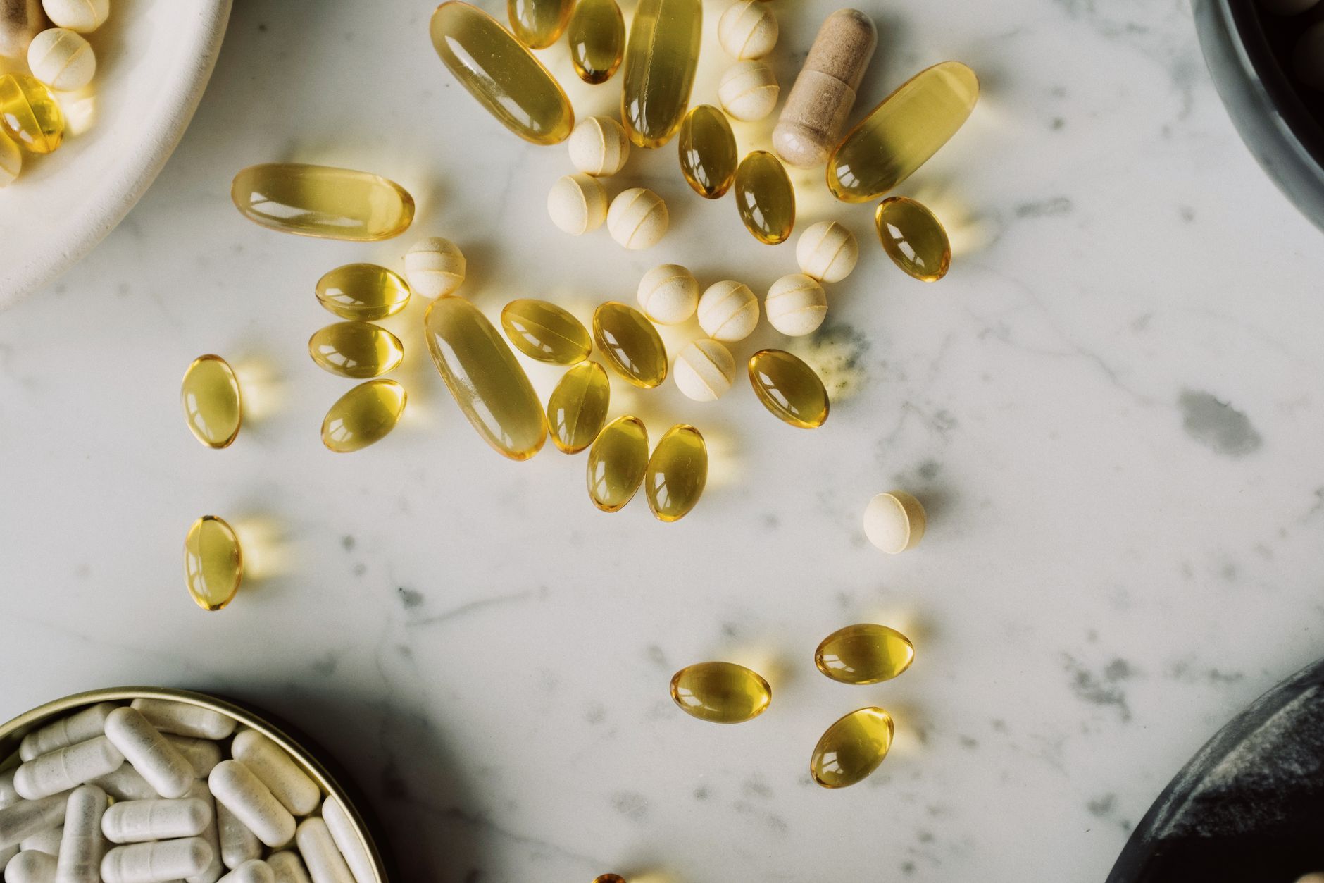 Softgel capsules and tablets spread on a table