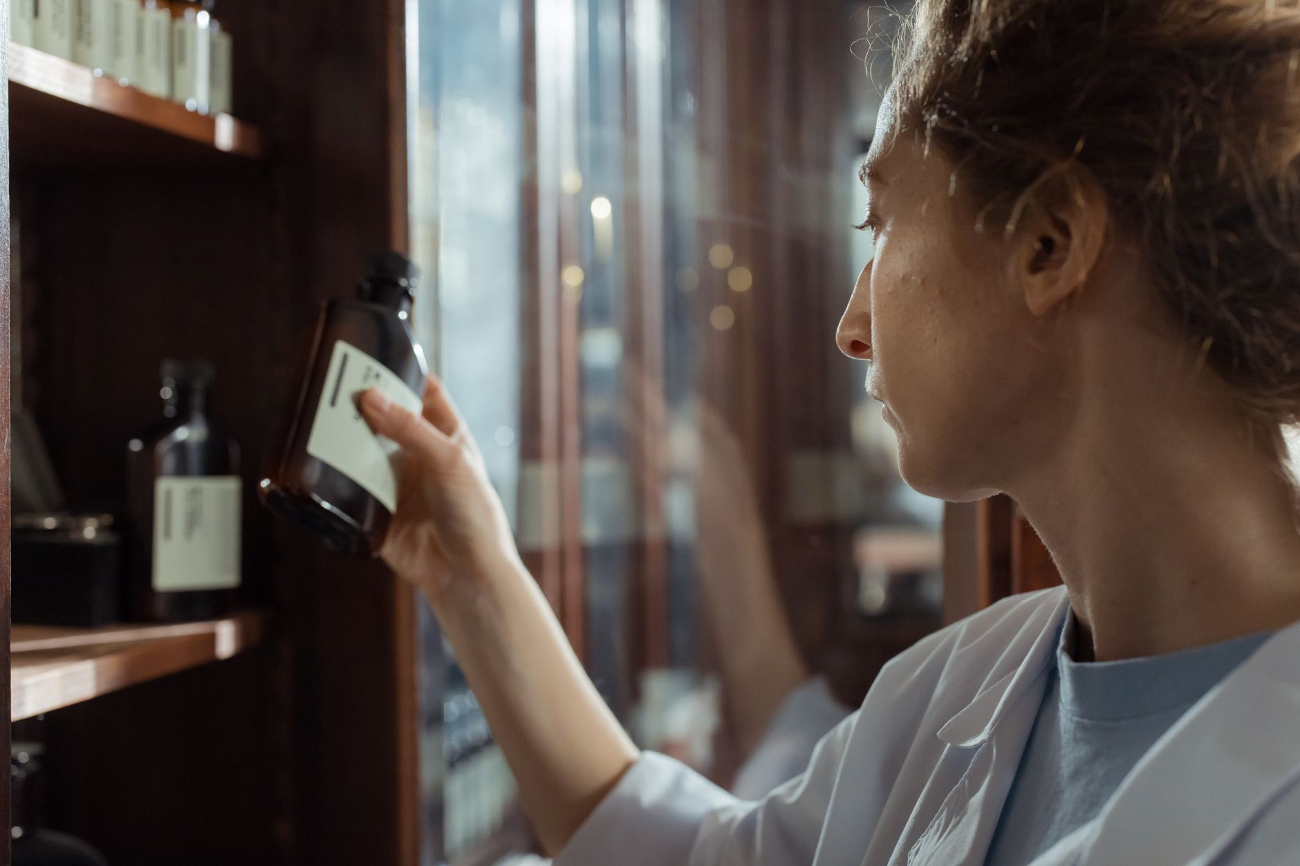 A woman reading the label on a medicine bottle