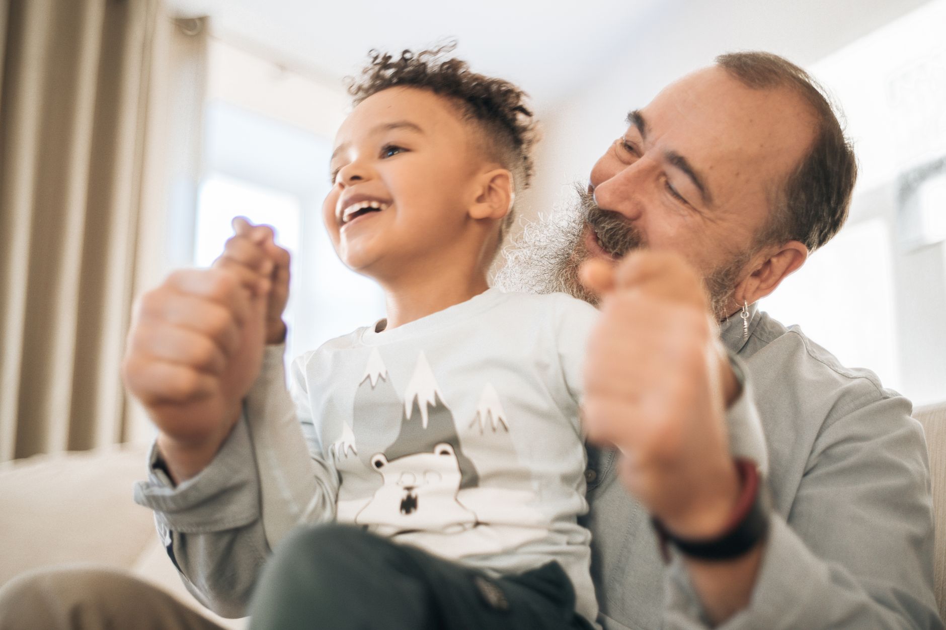 A grandfather laughing with a young child