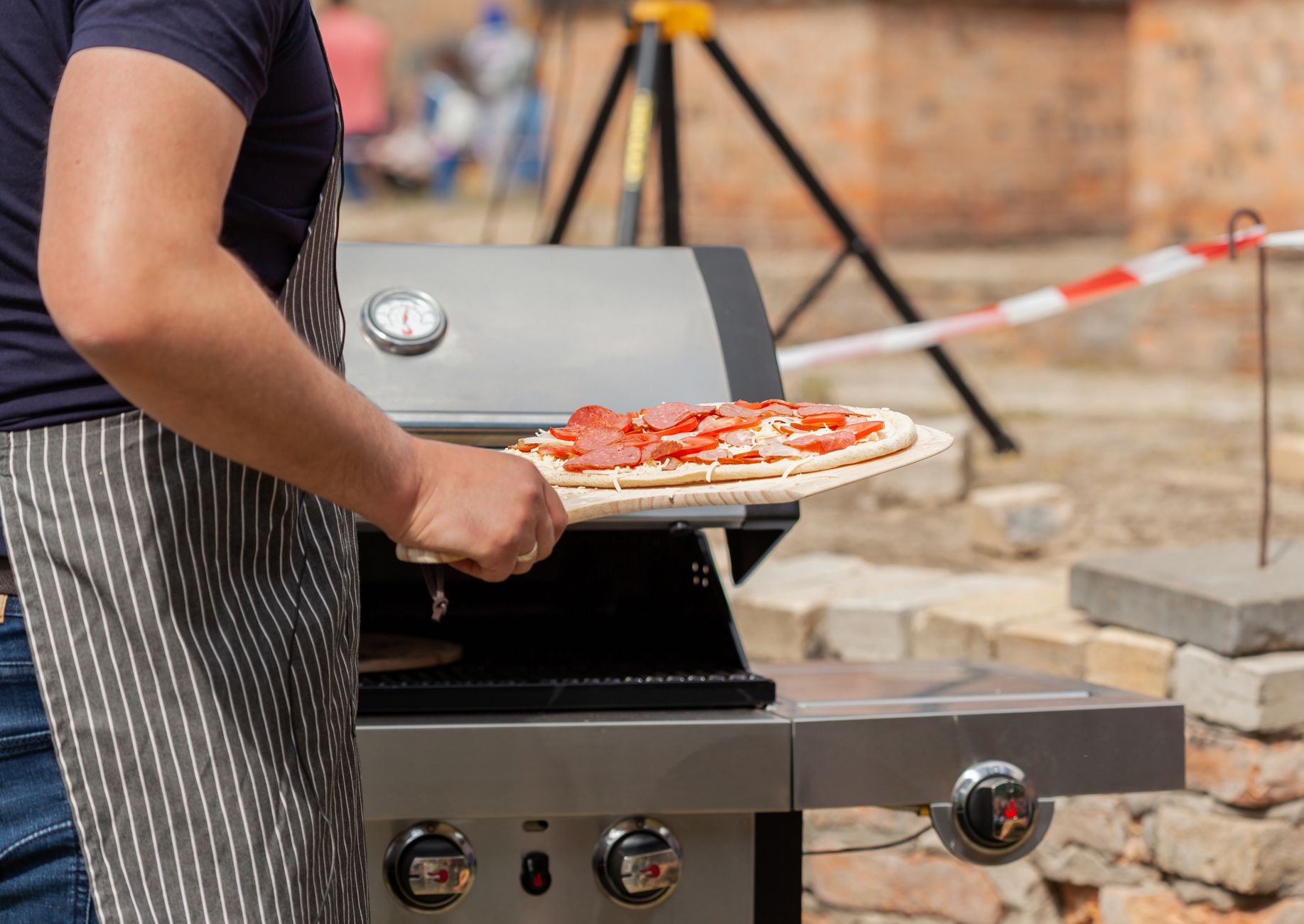 A pizza going into a gas pizza oven