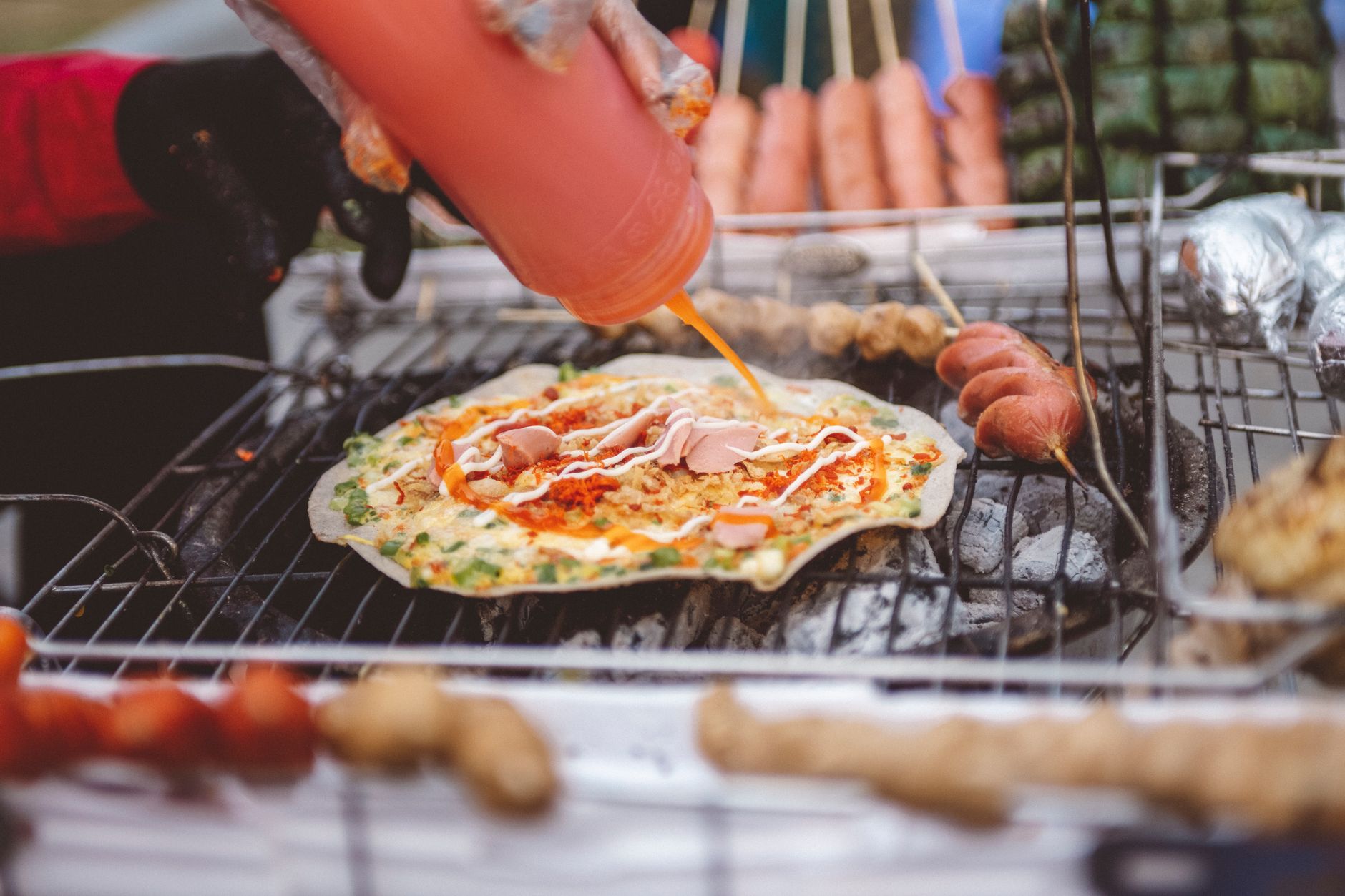 A pizza cooking on an outdoor grill