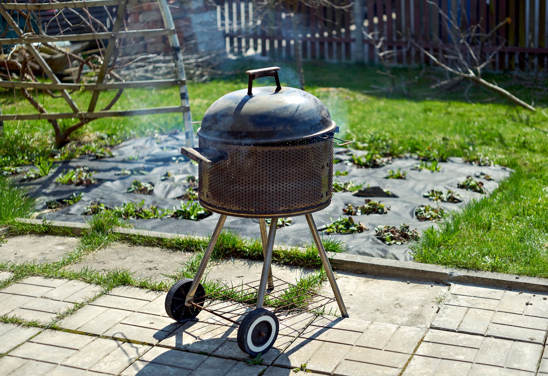A kettle grill on a backyard patio
