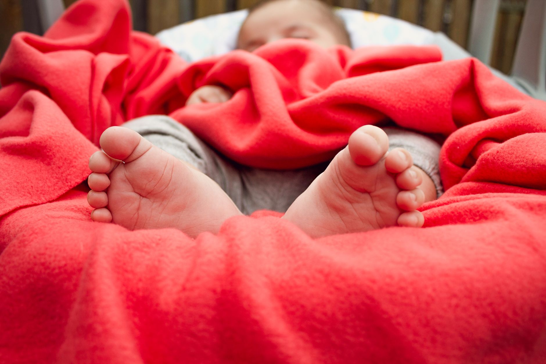 A baby’s feet resting on a soft blanket