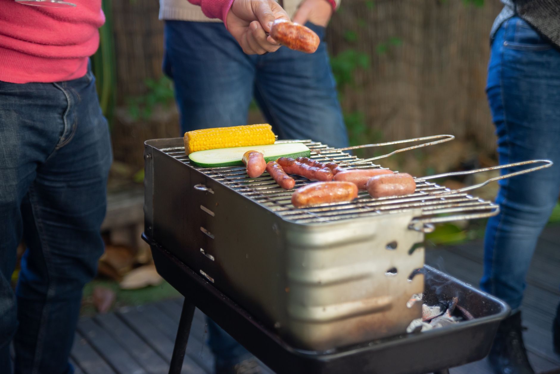 Sausages and corn on a portable grill