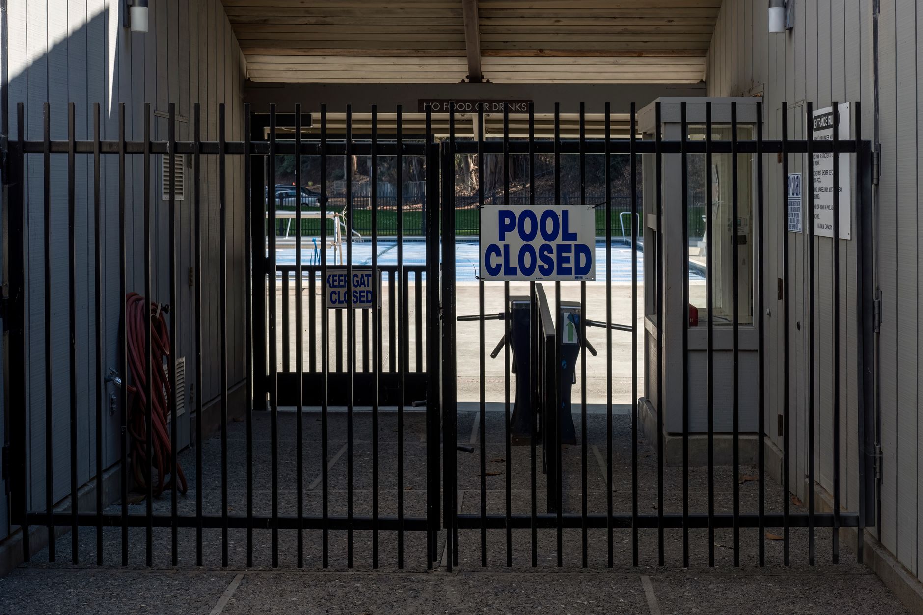 A locked gate in front of a closed pool