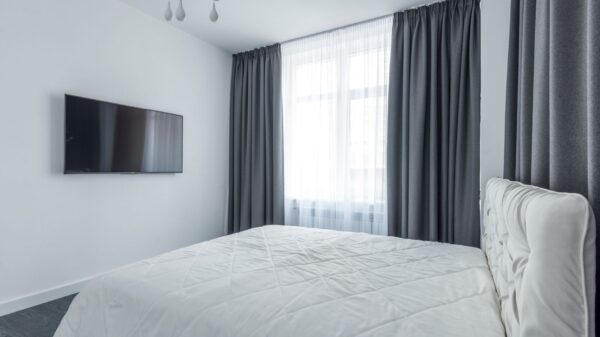 A bedroom with a TV on the wall