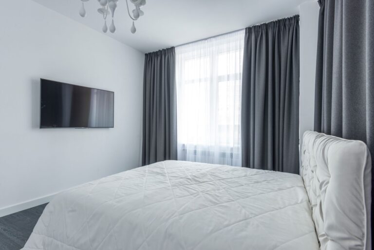 A bedroom with a TV on the wall