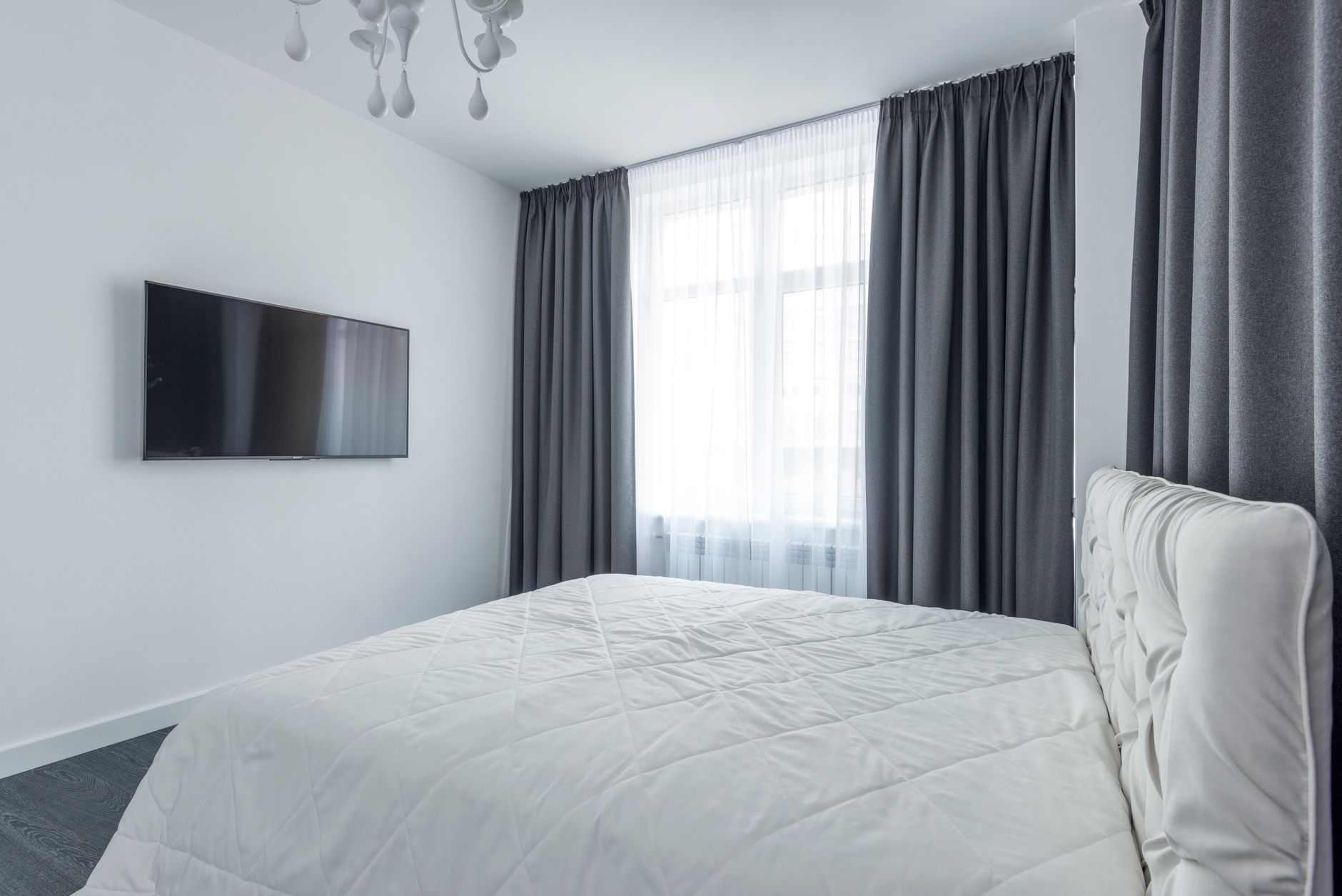 A bedroom with a TV on the wall