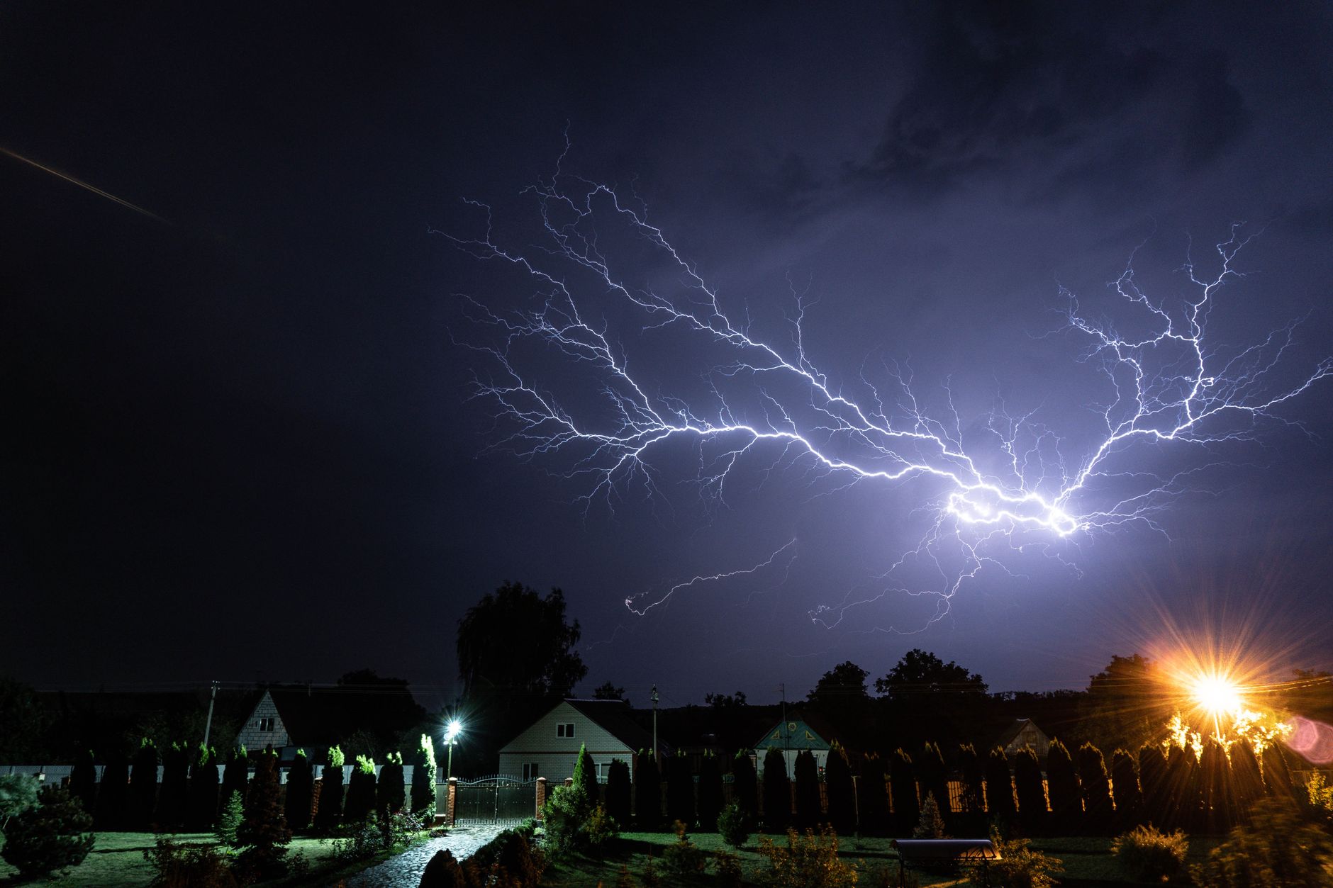 Lightning over houses at night