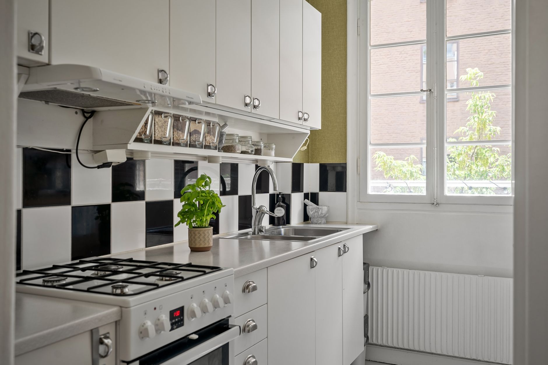 A small white kitchen with a gas stove