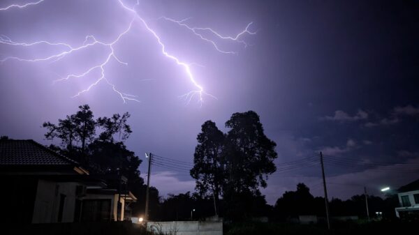 Lightning over houses and trees during a night storm